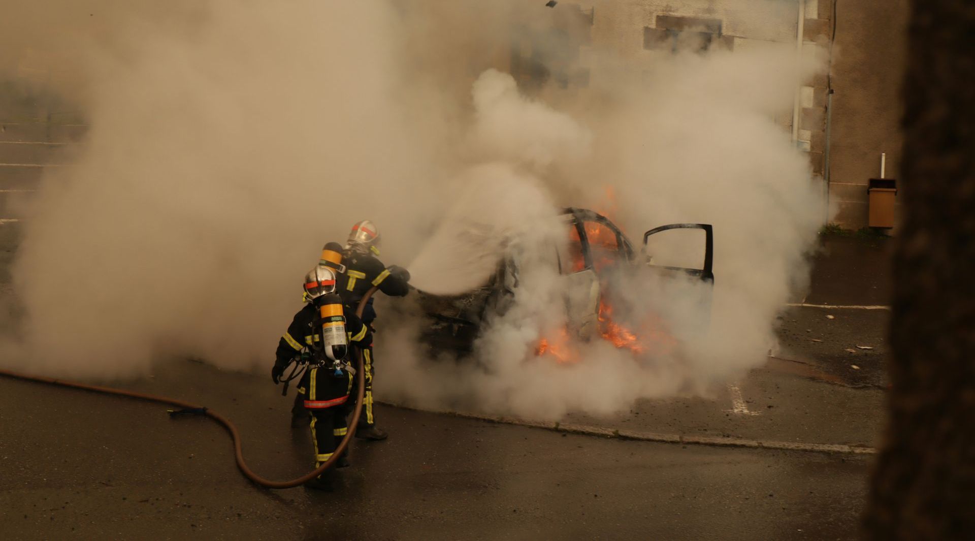 firemen putting out a fire in a car