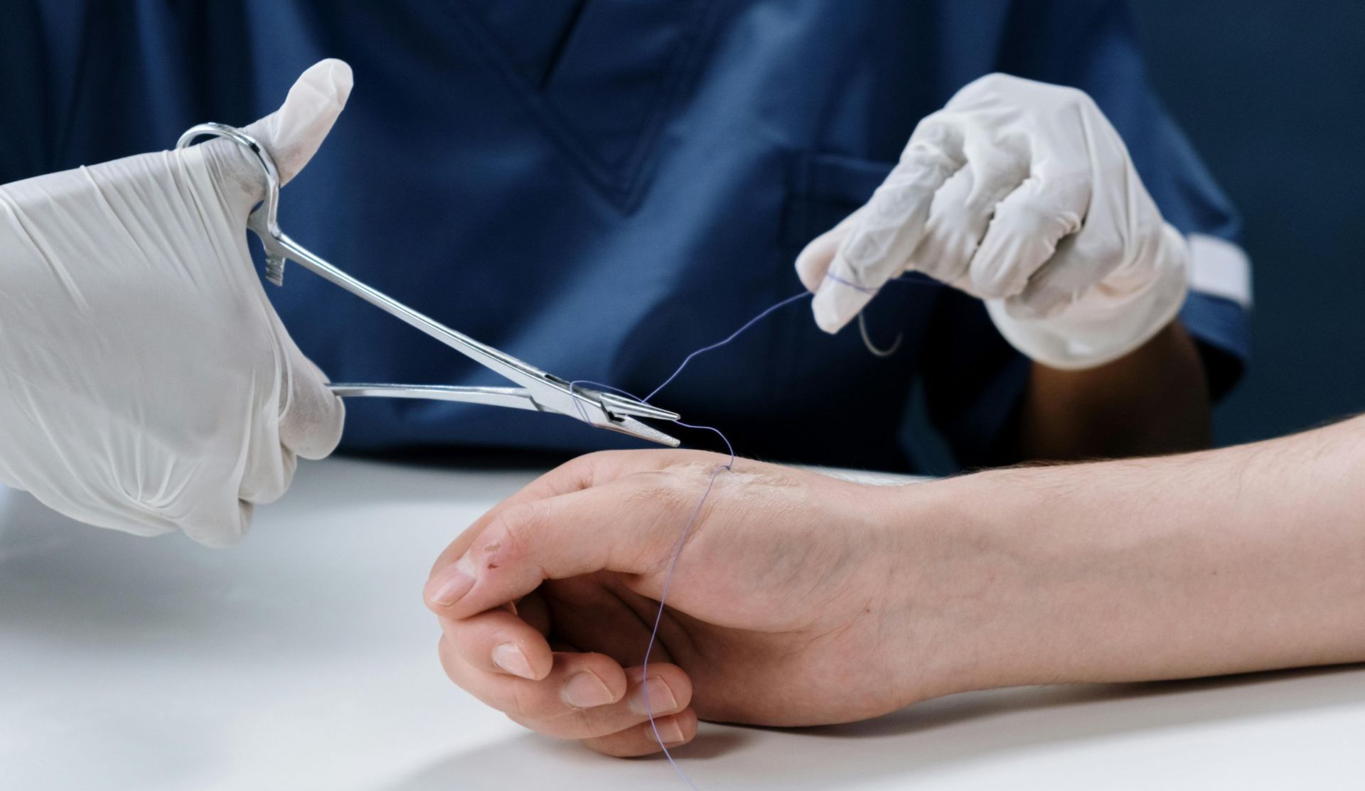 A person is getting a needle inserted into their wrist.