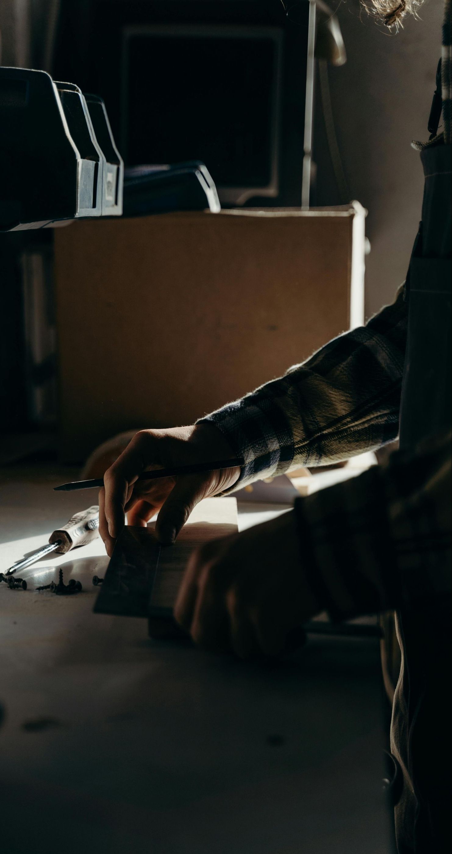 A man is sitting at a table working on a piece of equipment.