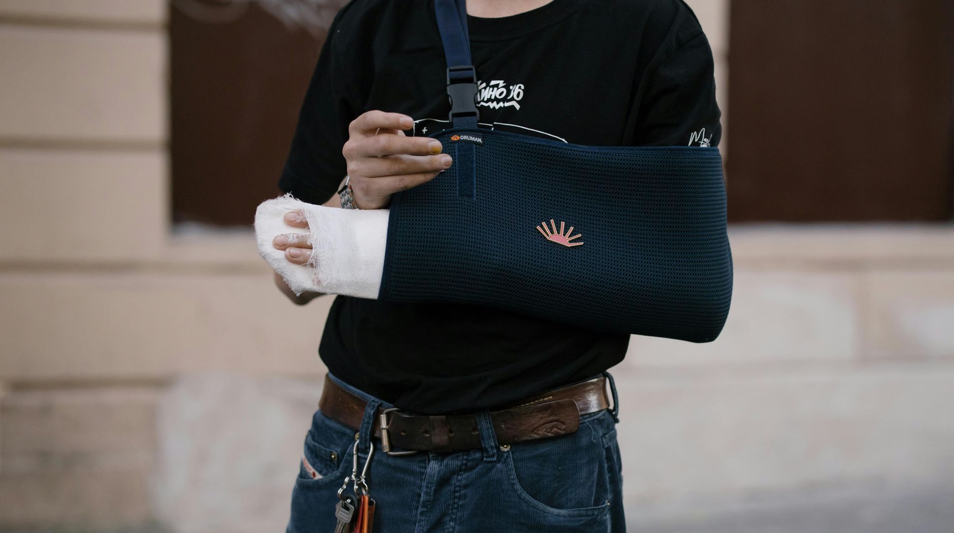 a man with a cast on his arm is walking down the street