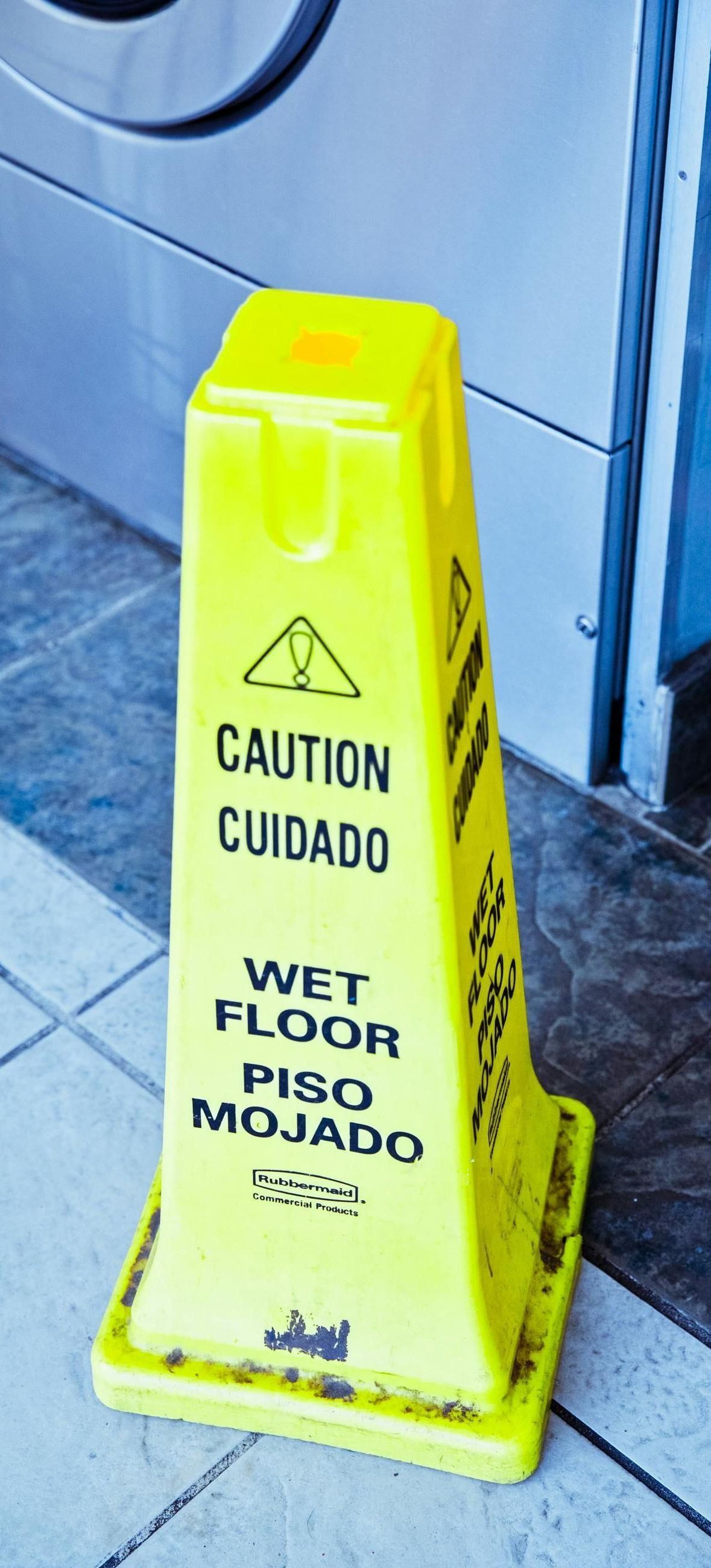a yellow caution sign that says wet floor piso mojado