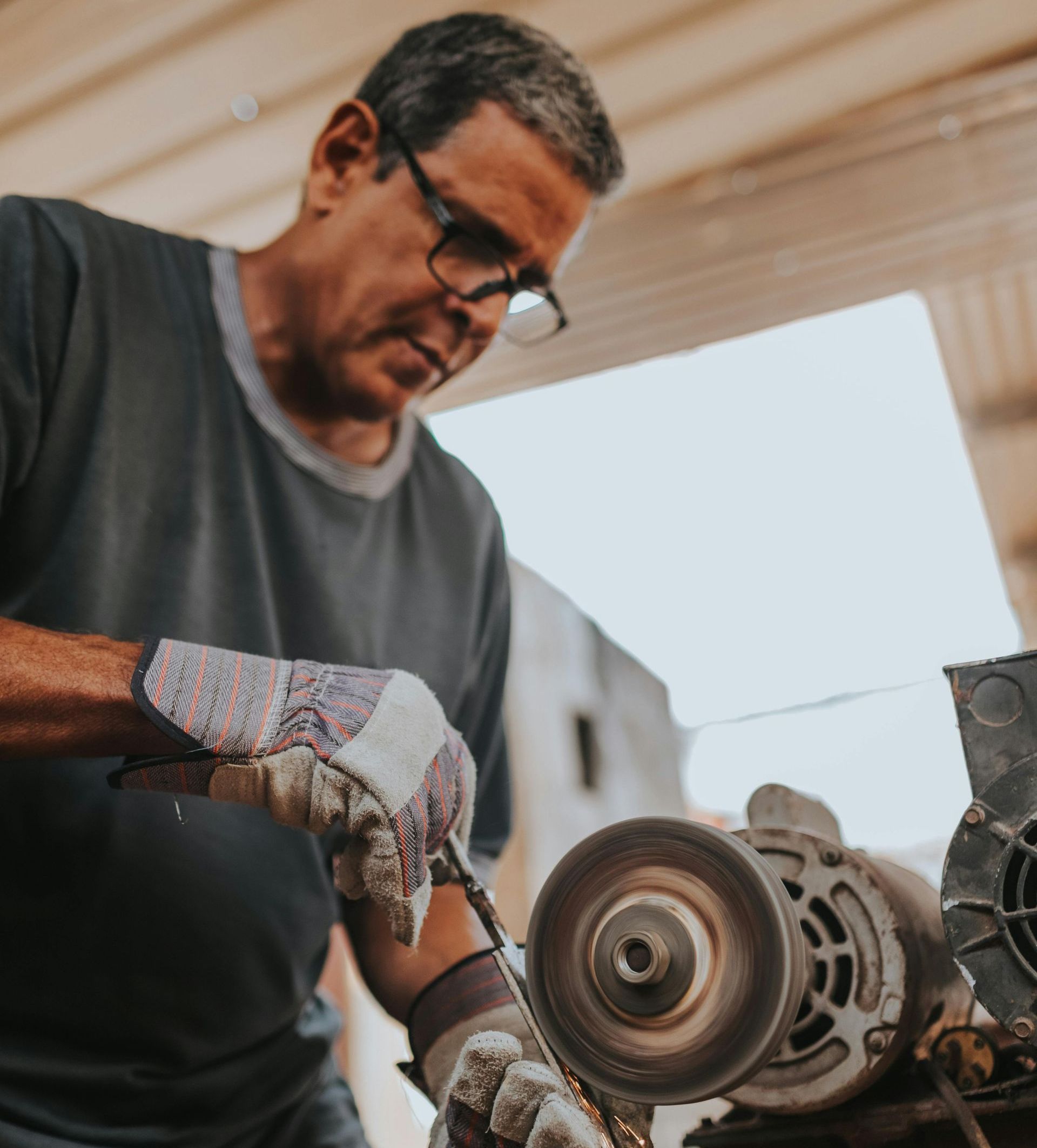 A man wearing gloves is working on a machine