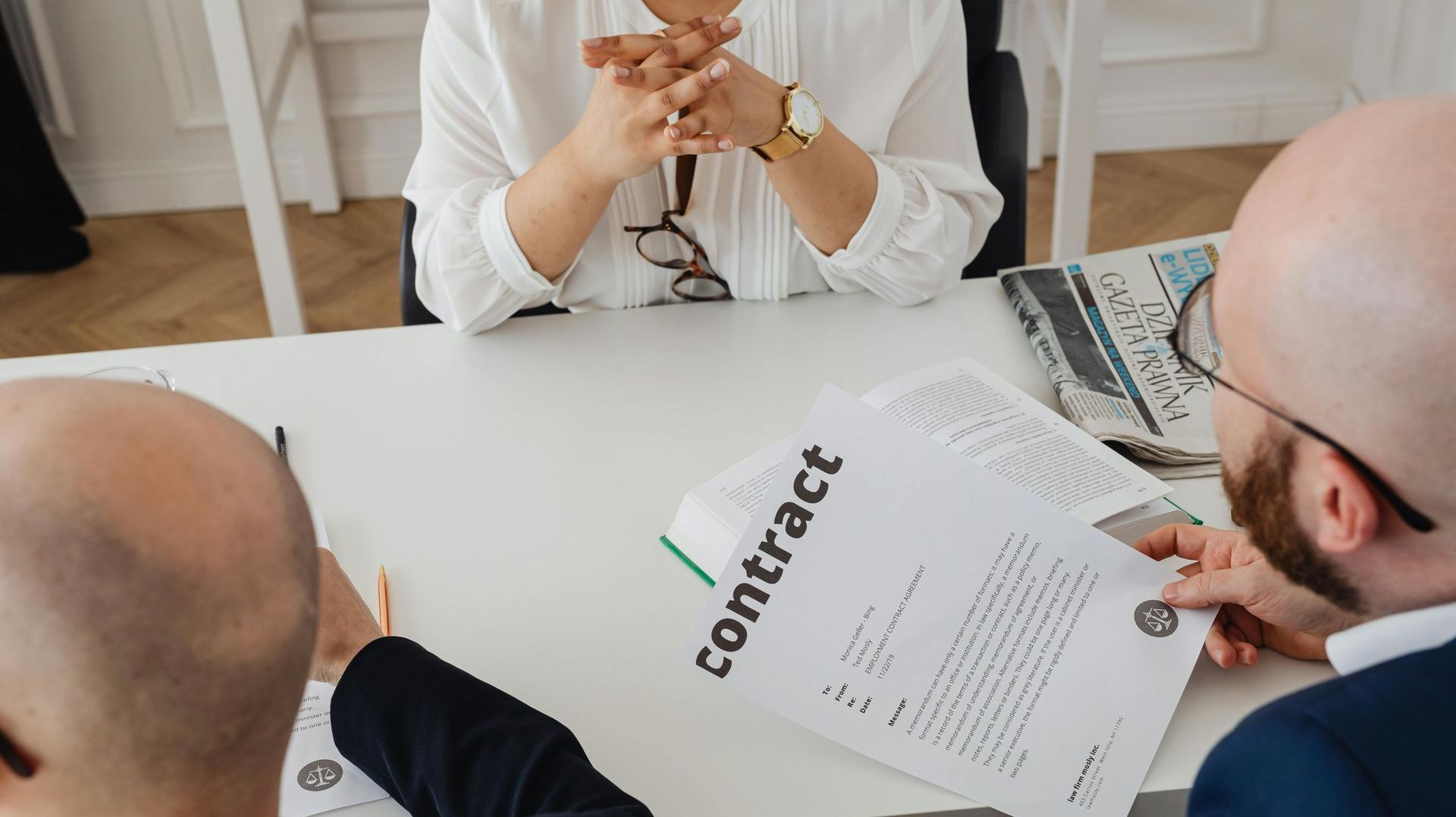 A group of people are sitting around a table looking at a contract.