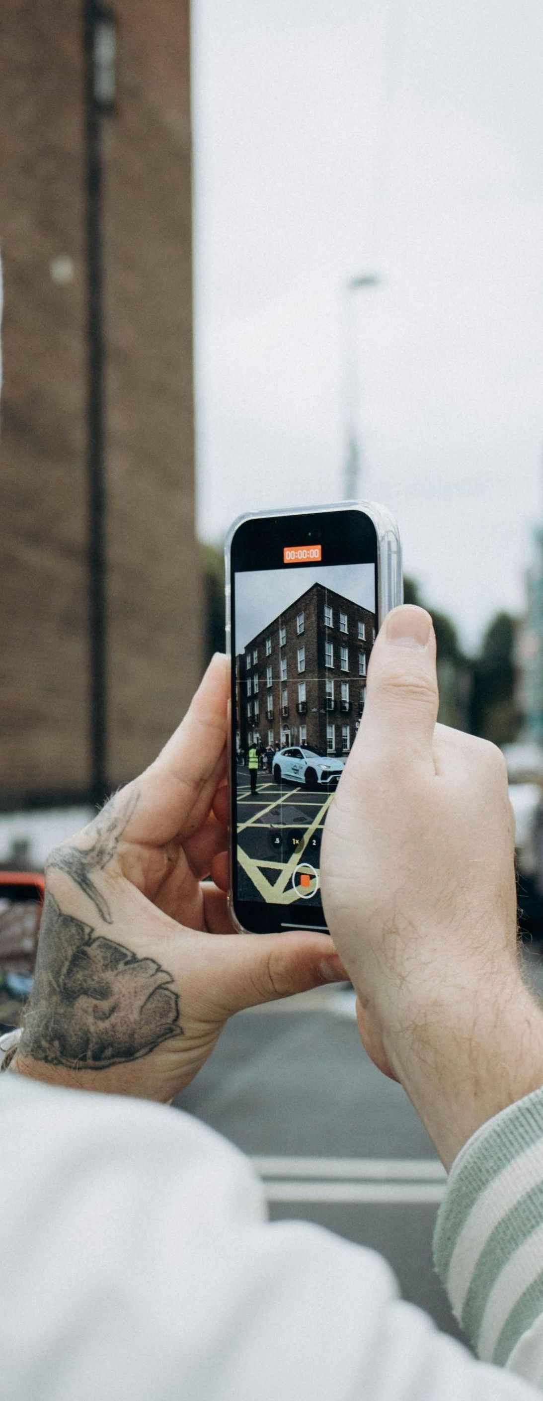 A person is taking a picture of a building with a cell phone.