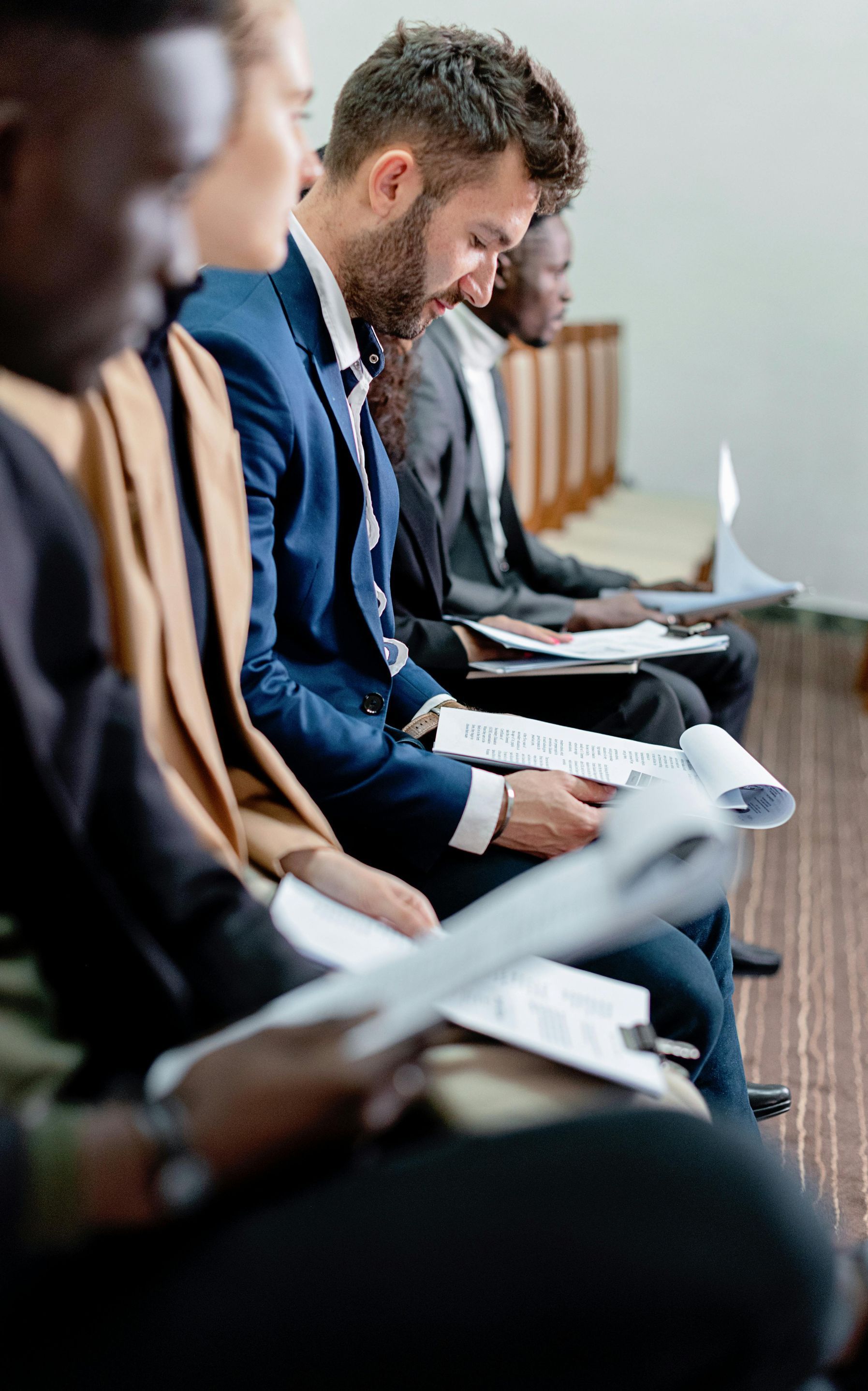 A group of people are sitting in a row in a courtroom.