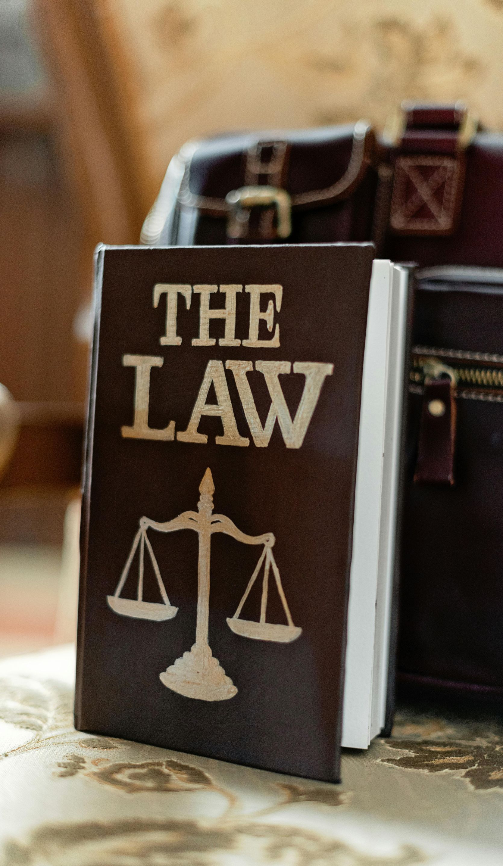 A book titled the law is sitting on a table next to a briefcase.