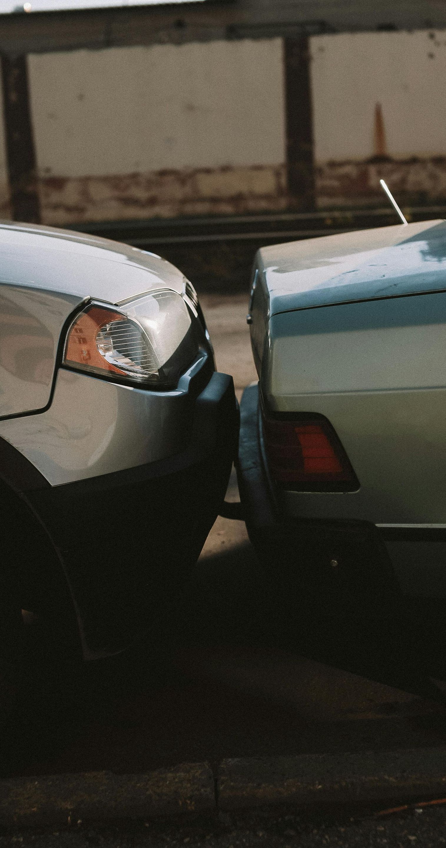 Two cars are parked next to each other on the side of the road