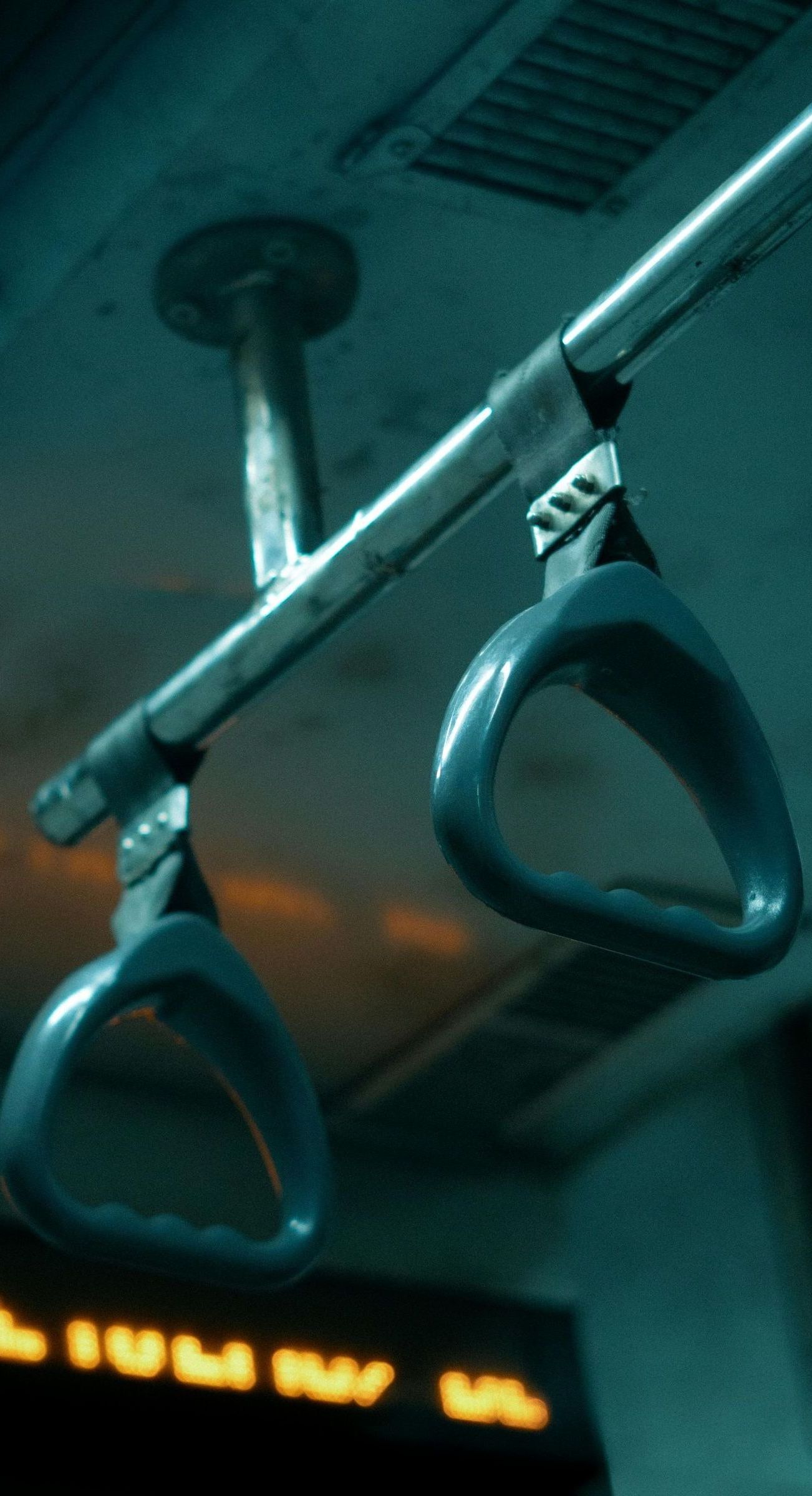 A pair of bus handles hanging from the ceiling