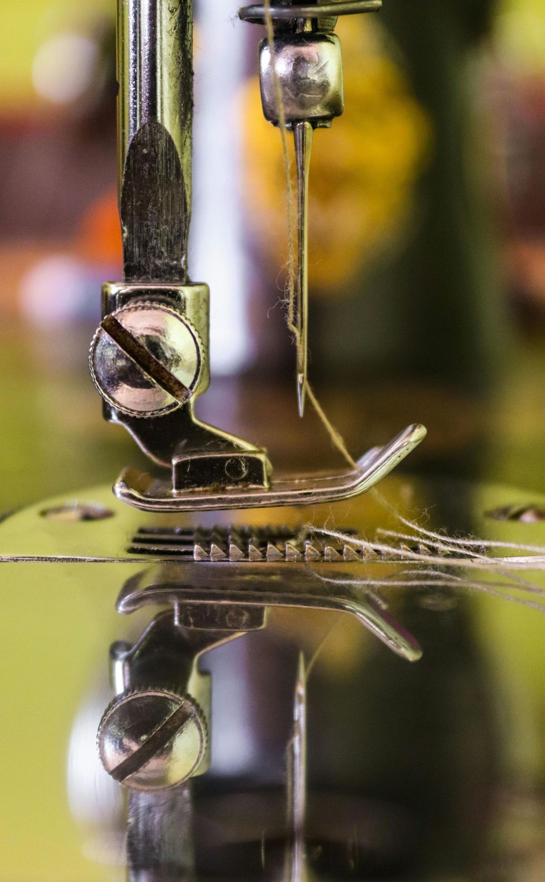 A close up of a sewing machine with a thread coming out of it.