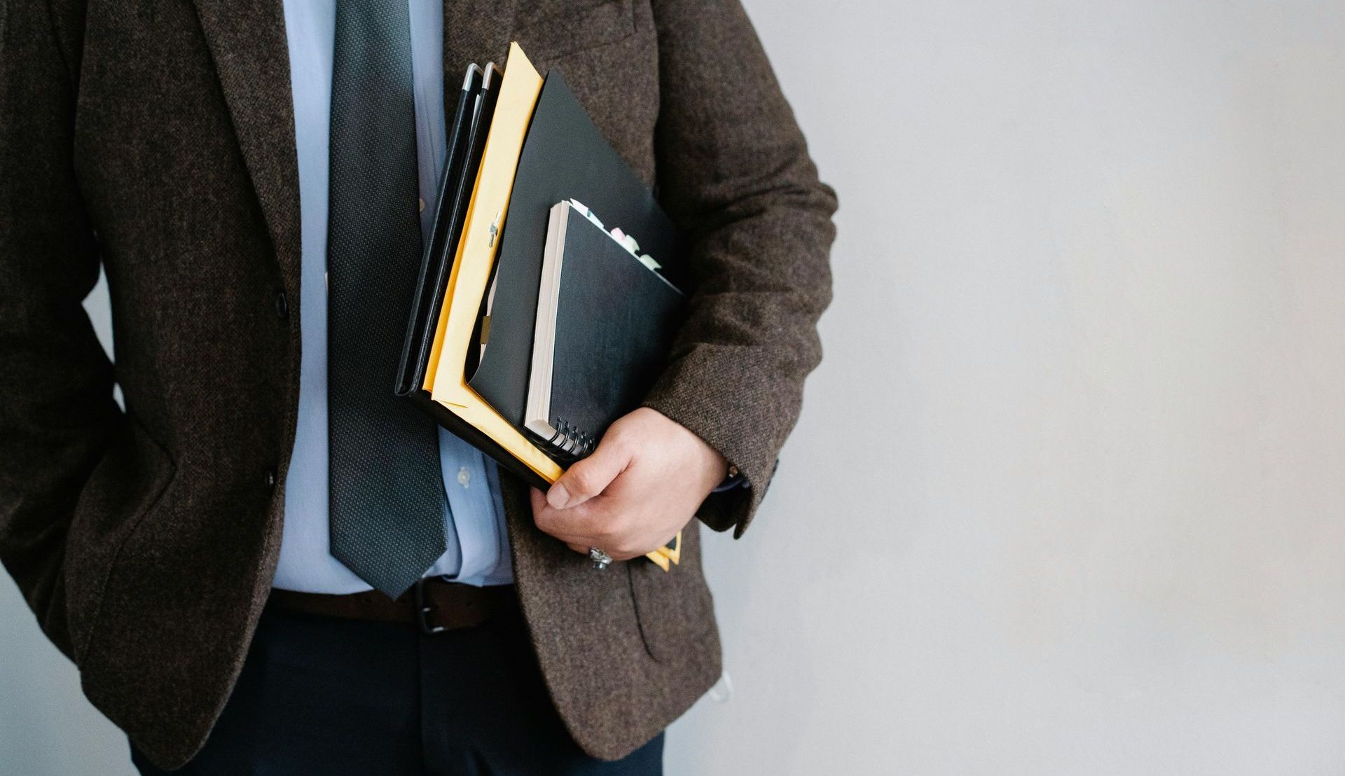 a man in a suit and tie is holding a stack of books.