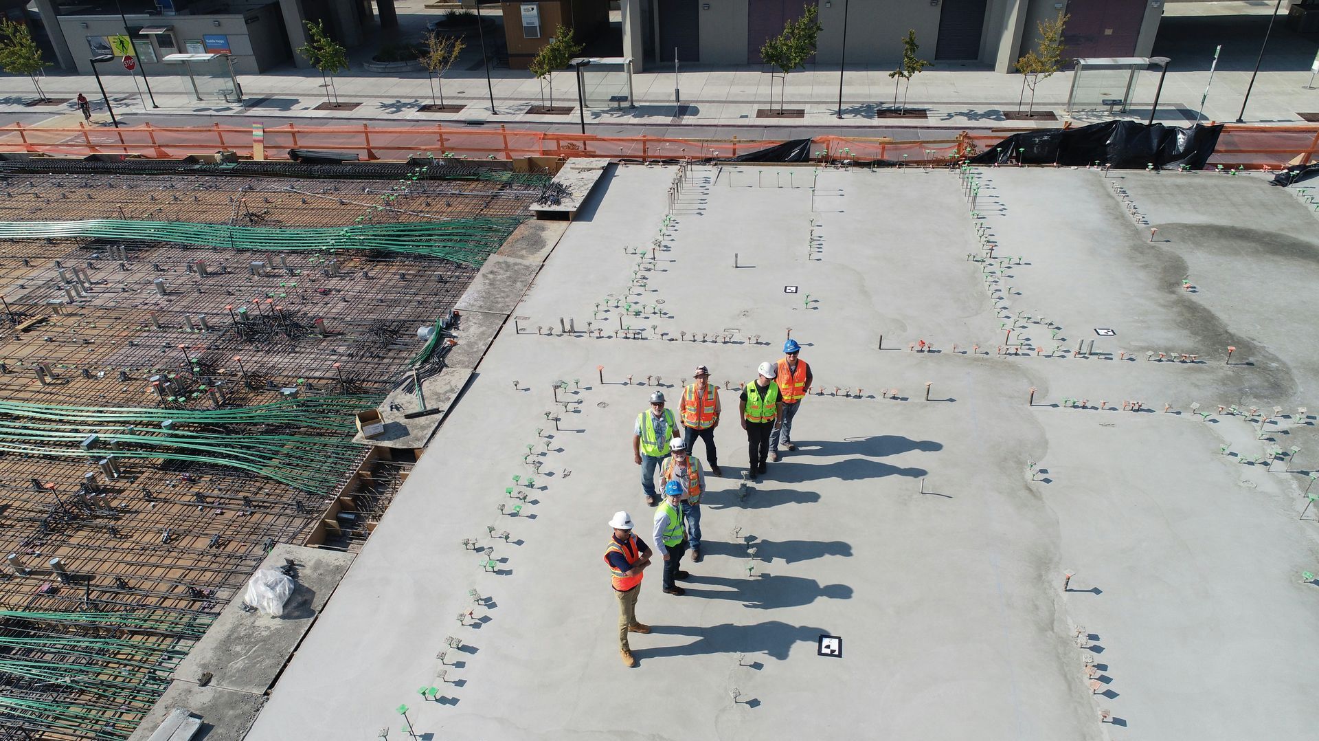 An aerial view of a group of construction workers standing on top of a concrete floor.