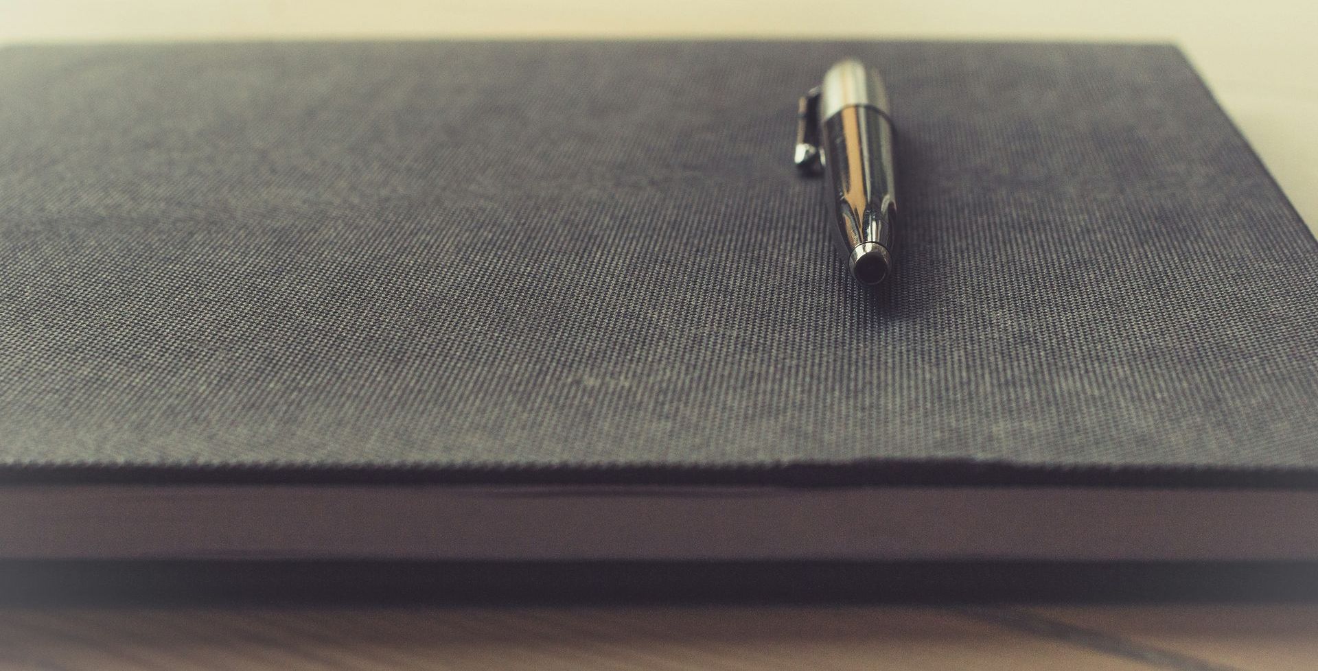 a pen is sitting on top of a black notebook 