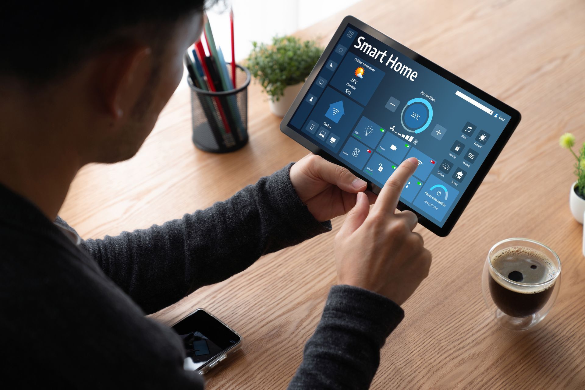 Un homme utilise une tablette pour contrôler sa maison intelligente.