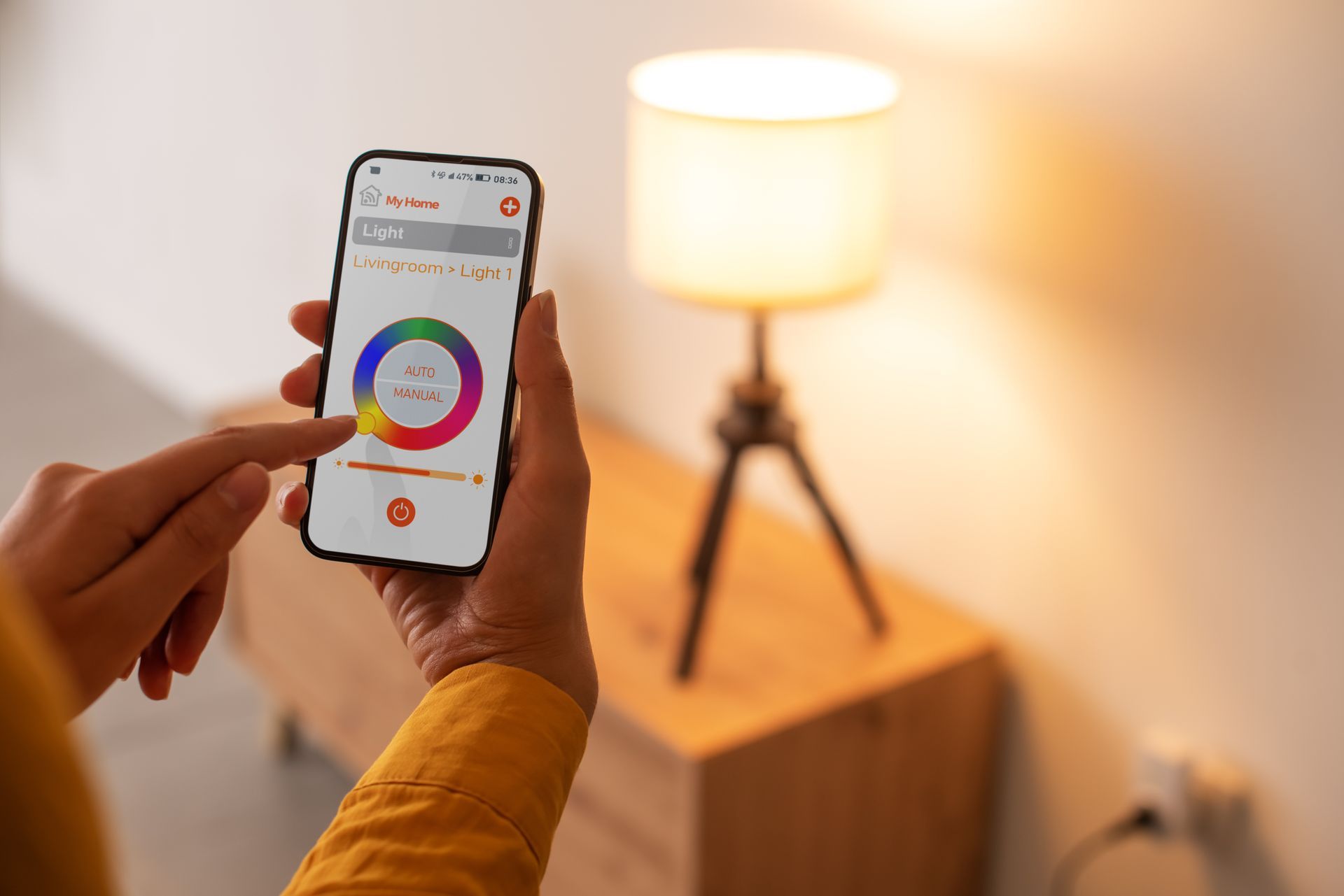 Une personne utilise un téléphone intelligent pour contrôler une lampe.
