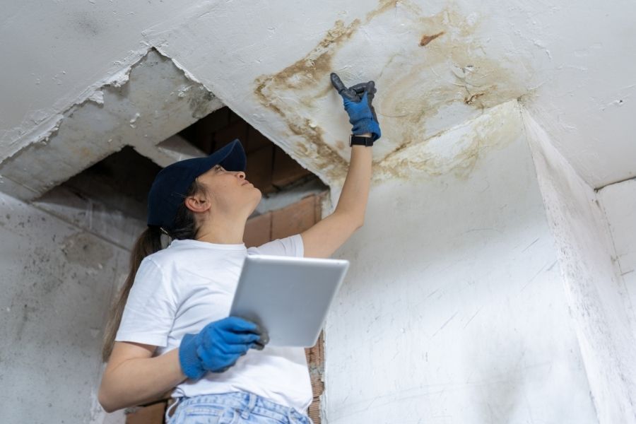 Technician inspecting ceiling water damage