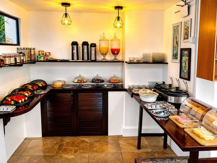 Mesa de buffet com bandejas de comida em uma sala de jantar com iluminação aconchegante.
