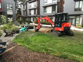 Yellow excavator bucket digging soil at a construction site