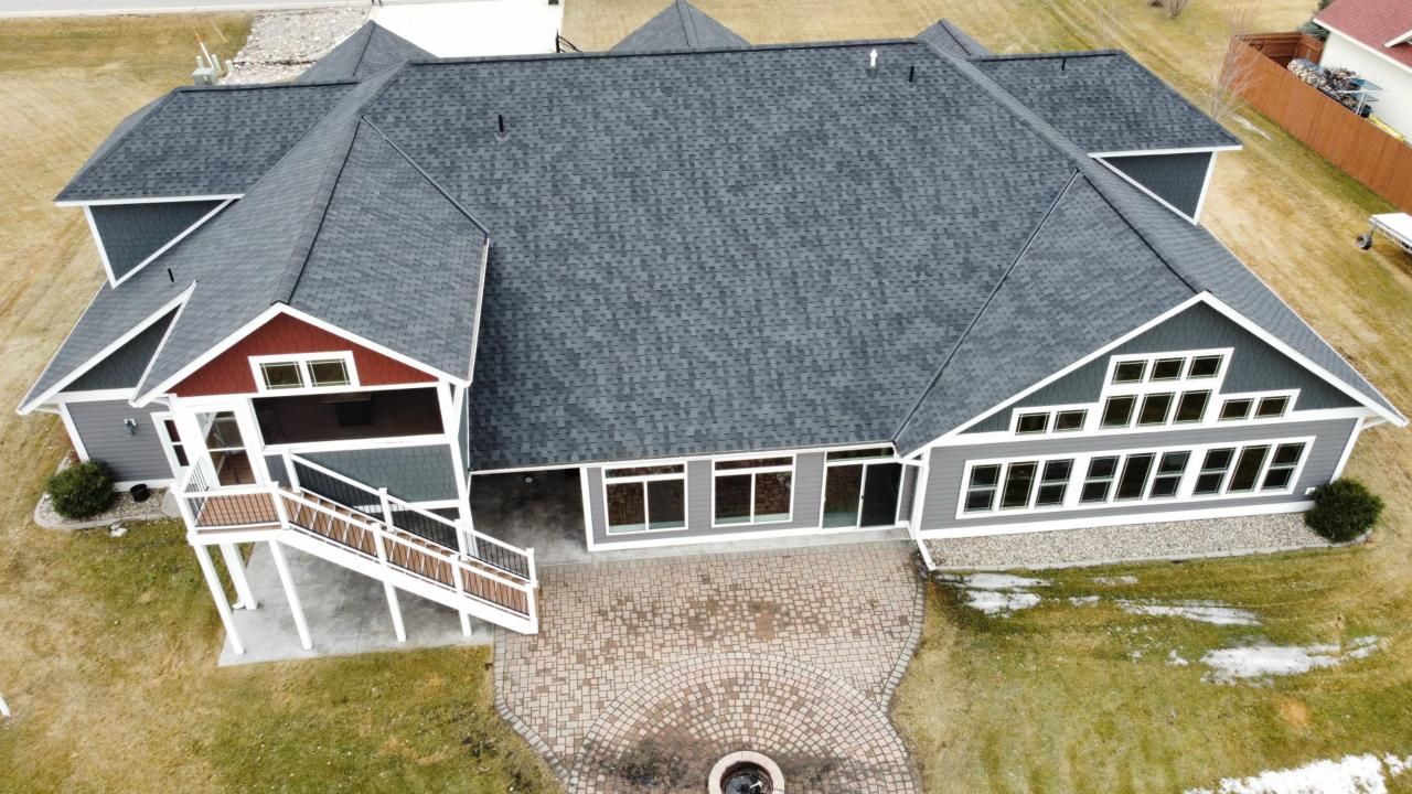 An aerial view of a large house with a gray roof