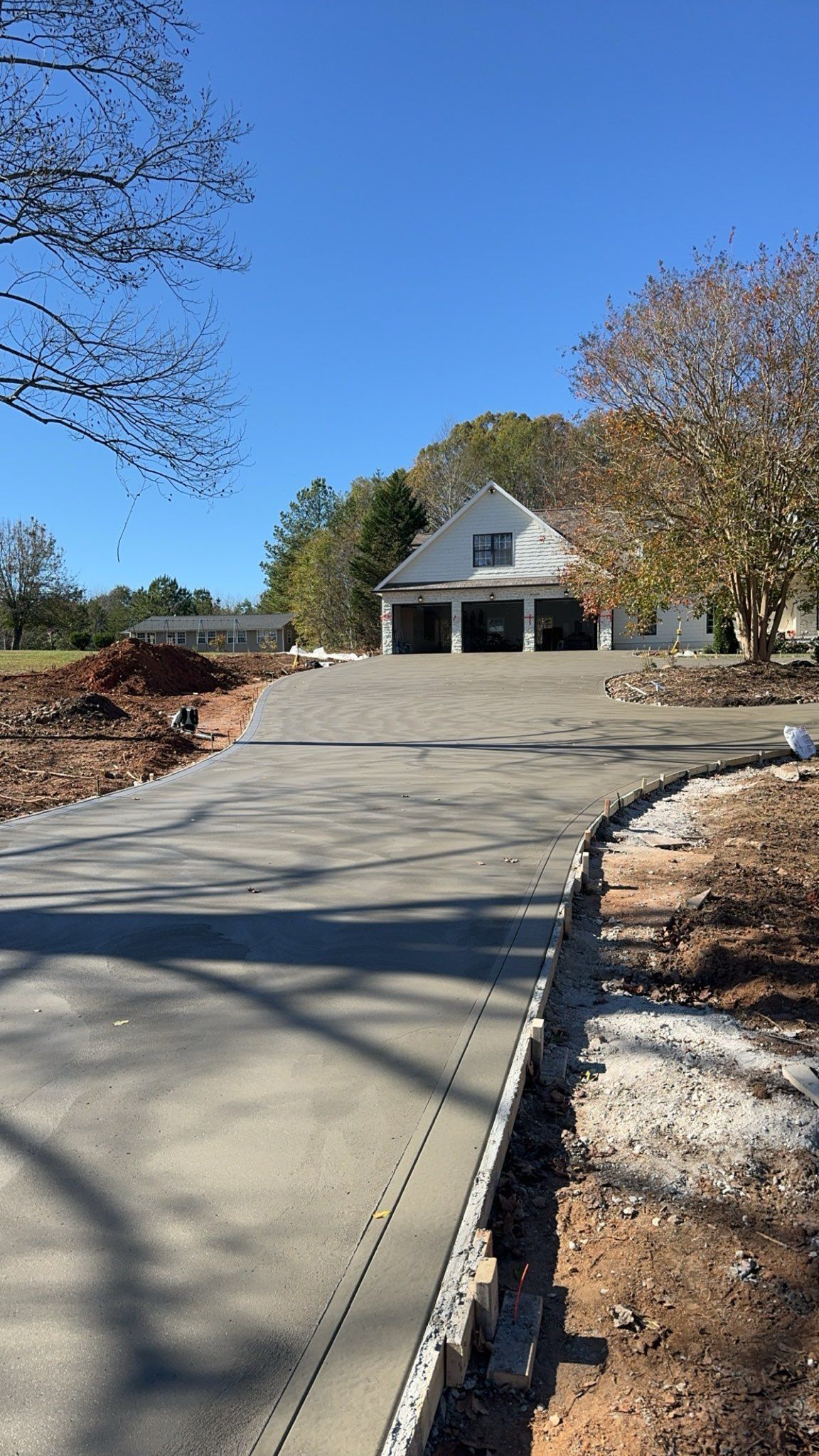 A concrete driveway is being built in front of a house.