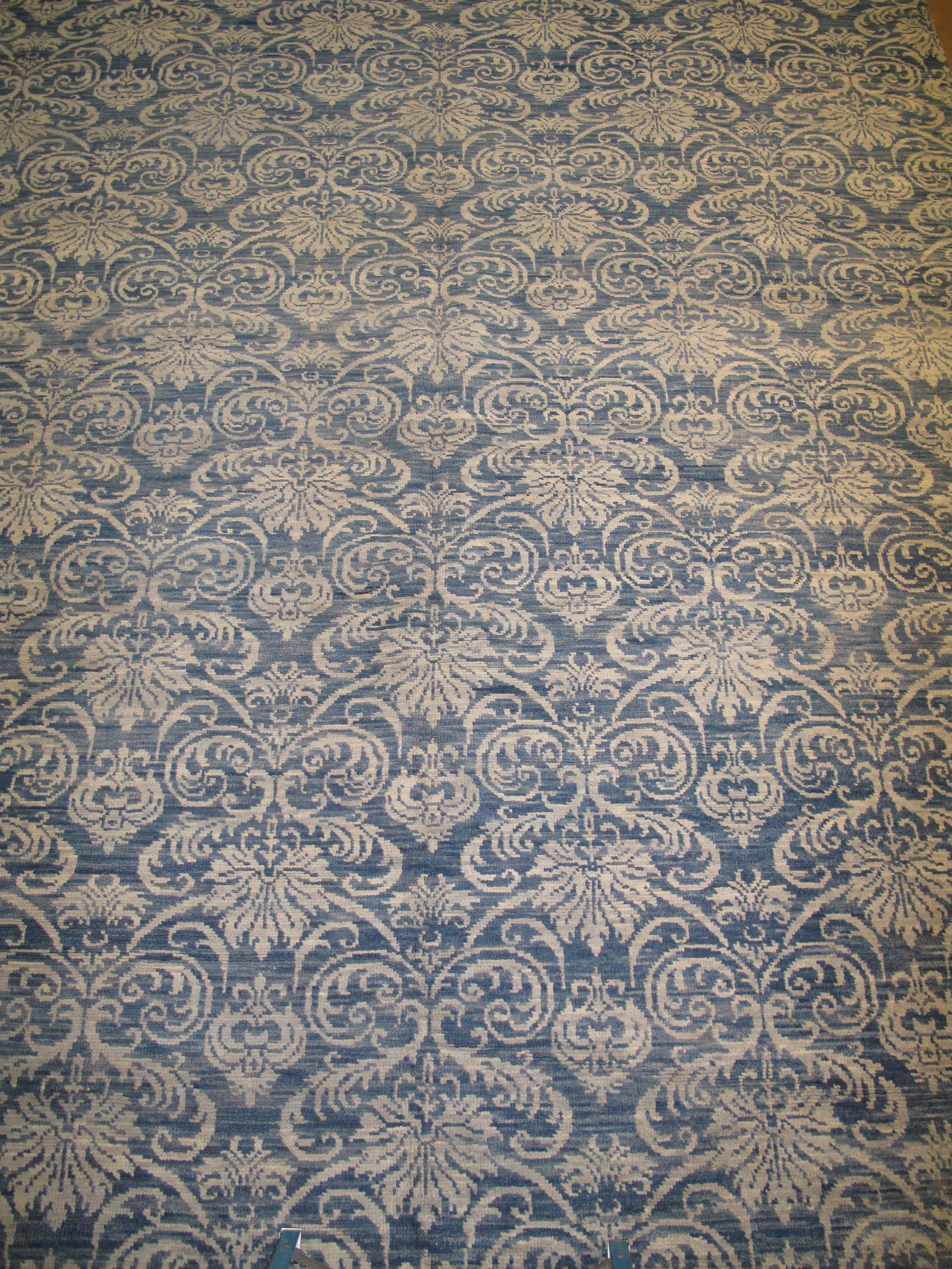 Blue and tan damask patterned rug.