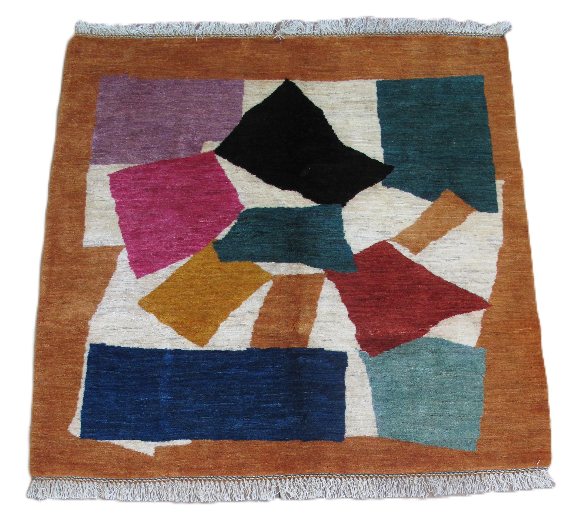 Square rug with geometric shapes in various colors set on a brown background.