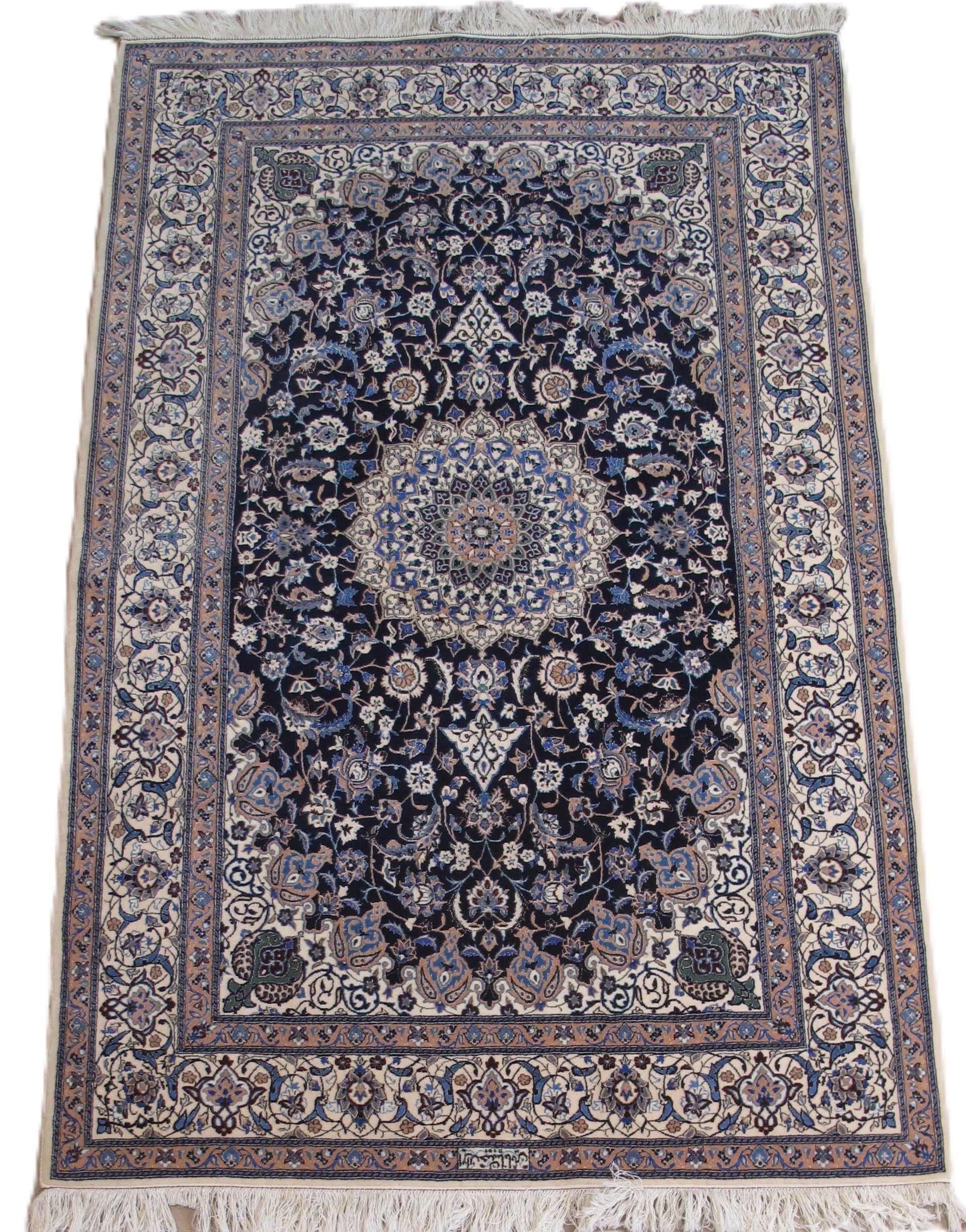 An ornate, rectangular Persian rug with a central medallion in blue and beige, surrounded by intricate floral patterns.