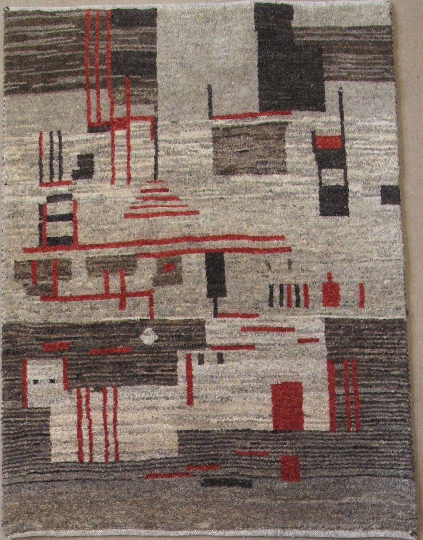 Abstract rug with geometric shapes in gray, brown, and red.