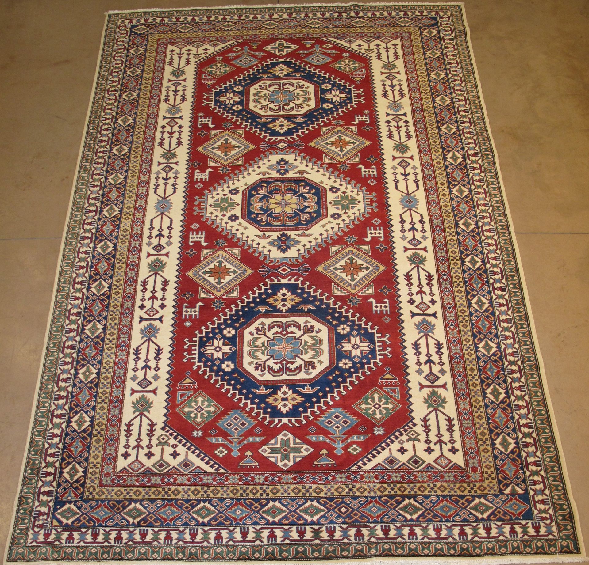 Oriental rug with red central field and geometric patterns in blue, beige, and brown.