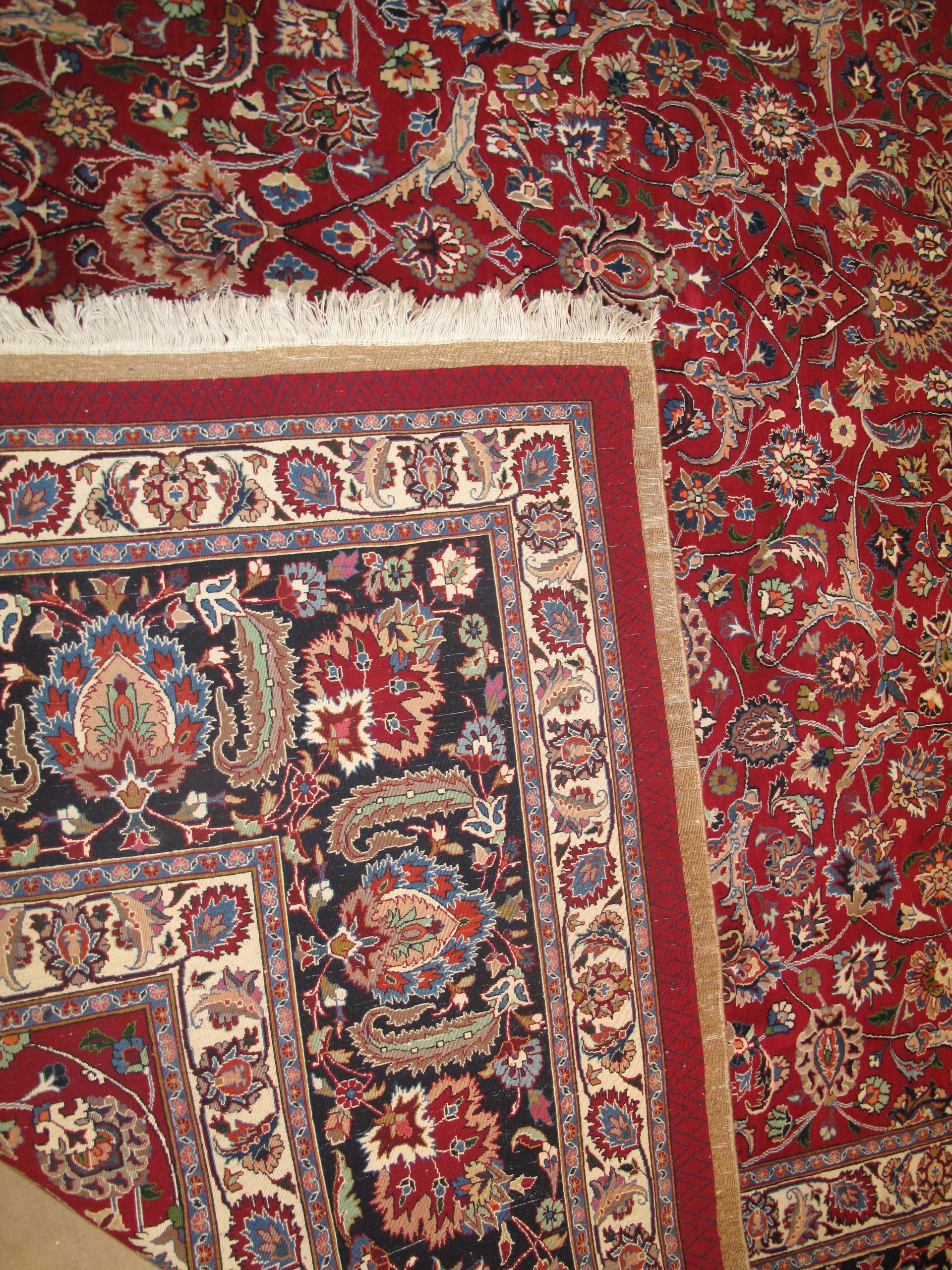 Red Persian rug with floral patterns and ornate border.