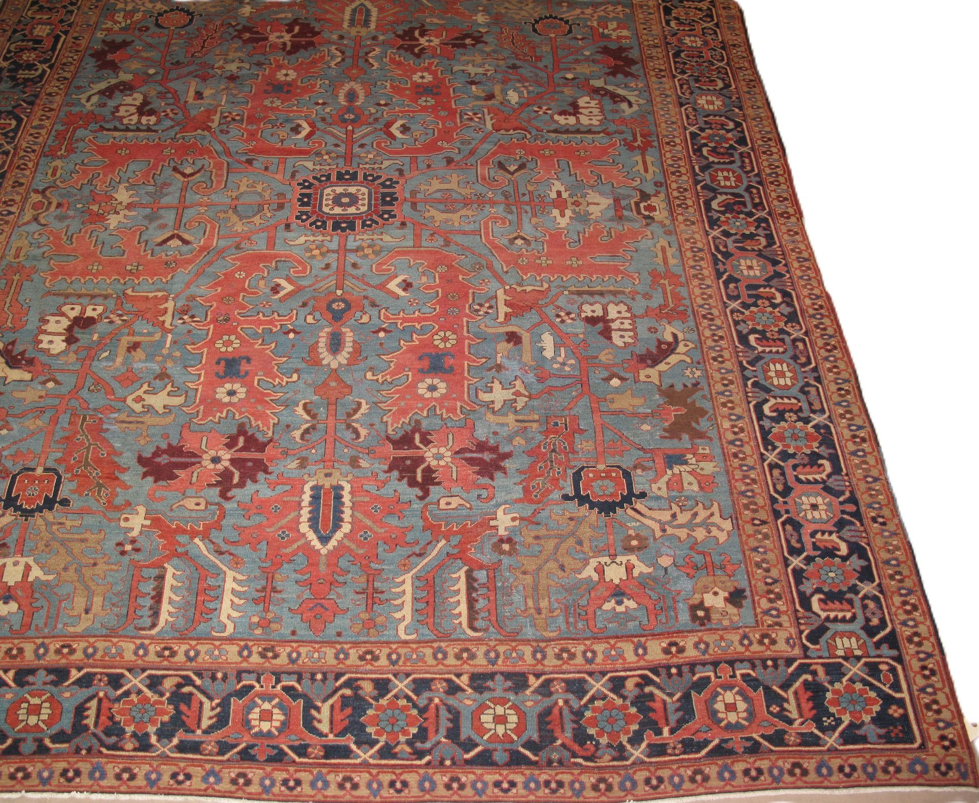 Ornate red and blue patterned rug with floral motifs, viewed from above on a light background