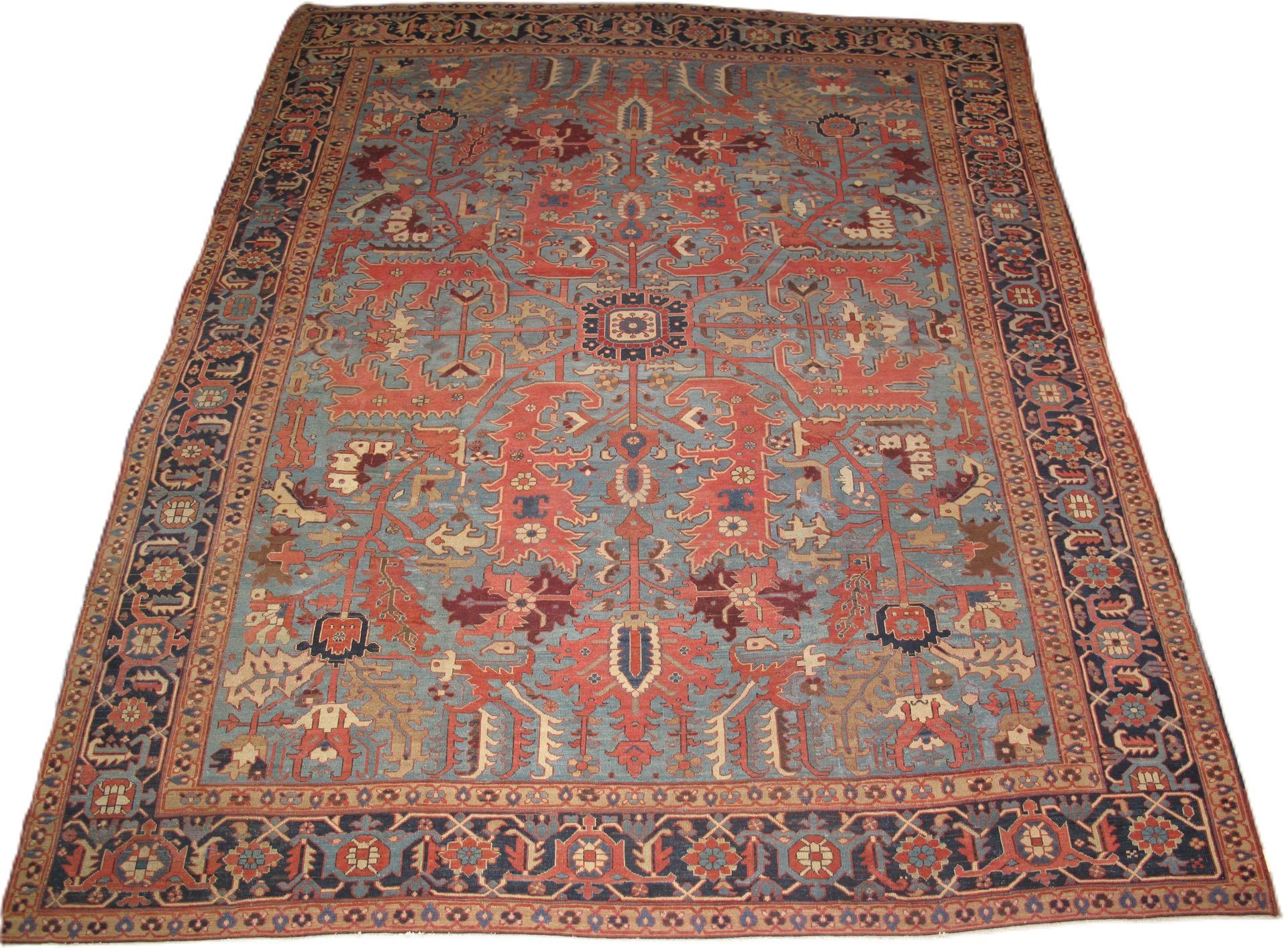 Ornate red and blue patterned rug with floral motifs, viewed from above on a light background