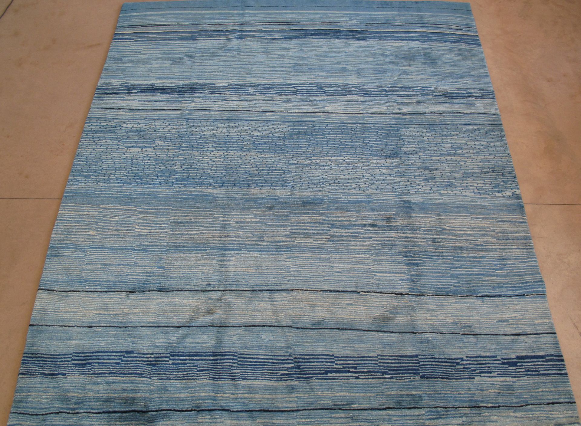 Blue and gray rectangular rug with horizontal textured pattern.