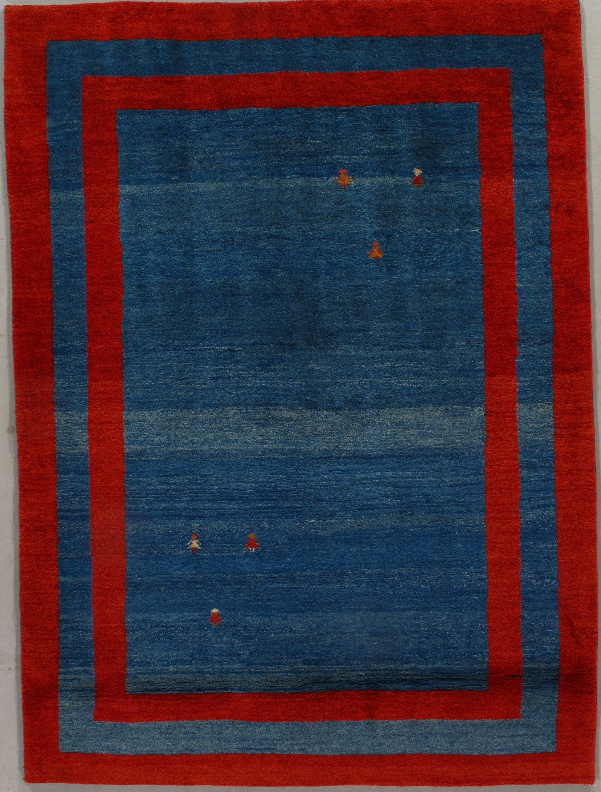 Blue and red rectangular rug with a double border, scattered brown accents.