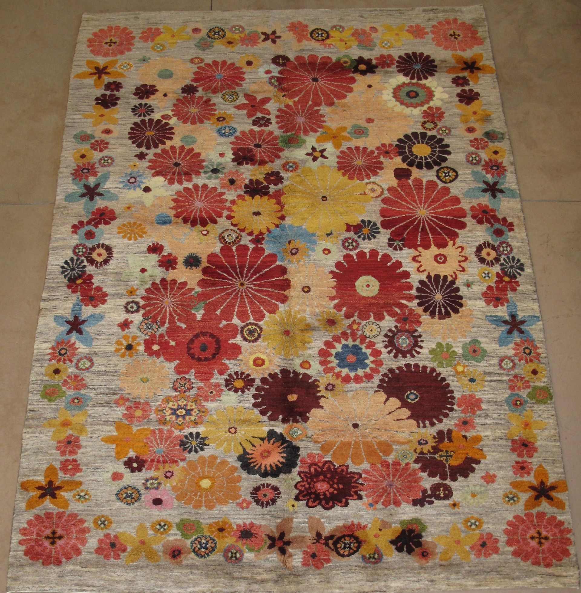Beige rug with colorful floral pattern.