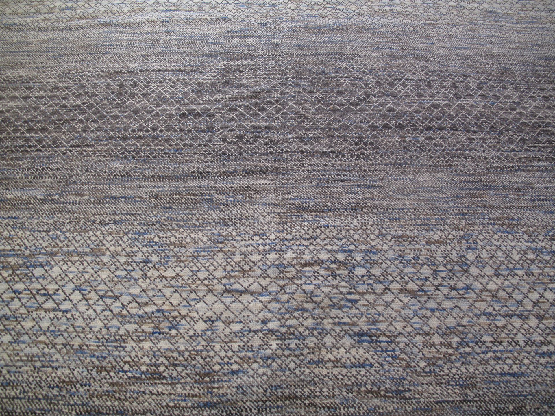Gray textured fabric with a subtle blue-and-brown woven pattern.