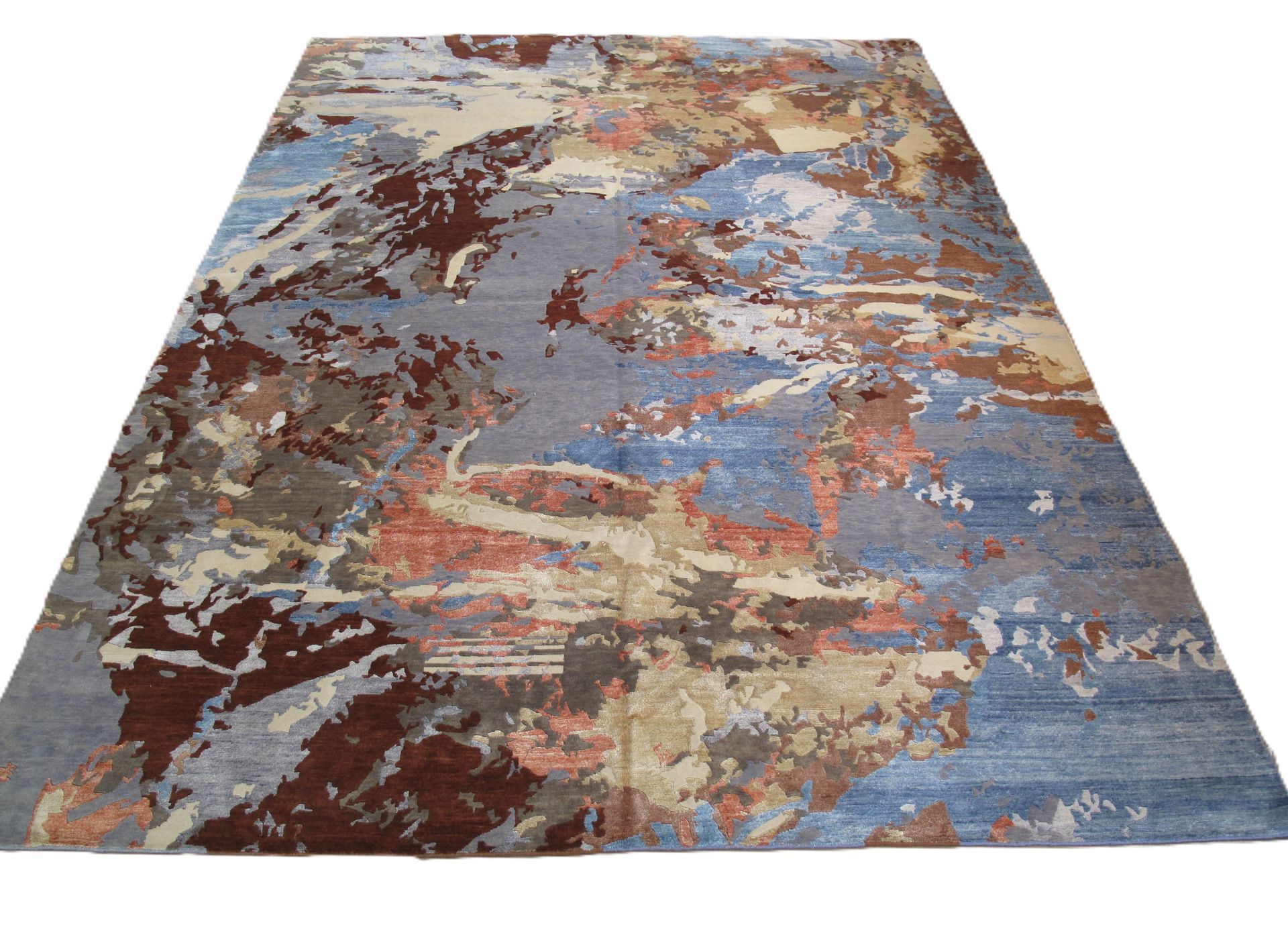 Abstract rug with shades of blue, brown, beige, and gray.