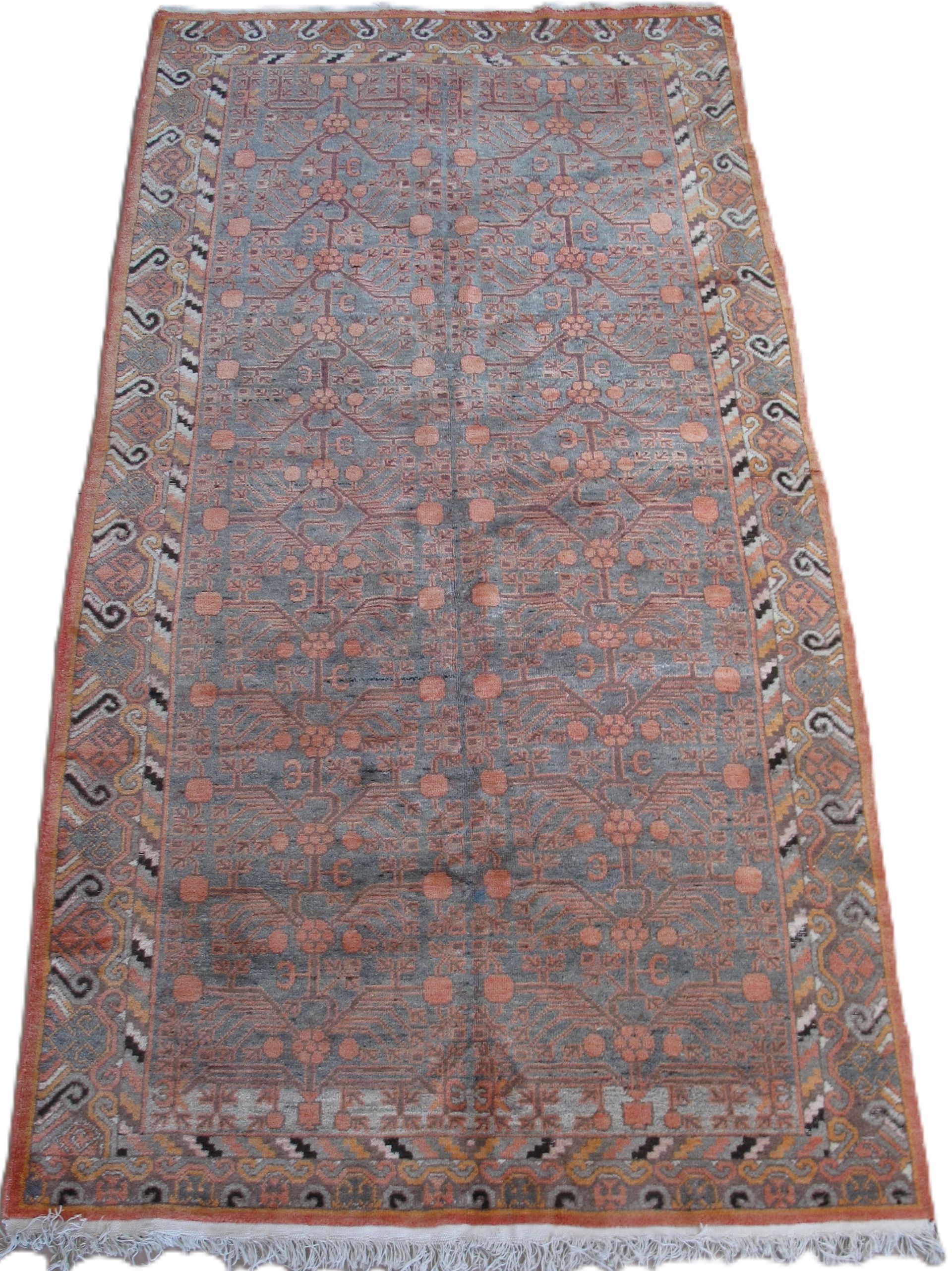 Rectangular brown oriental rug with patterned border and repeating floral motifs.