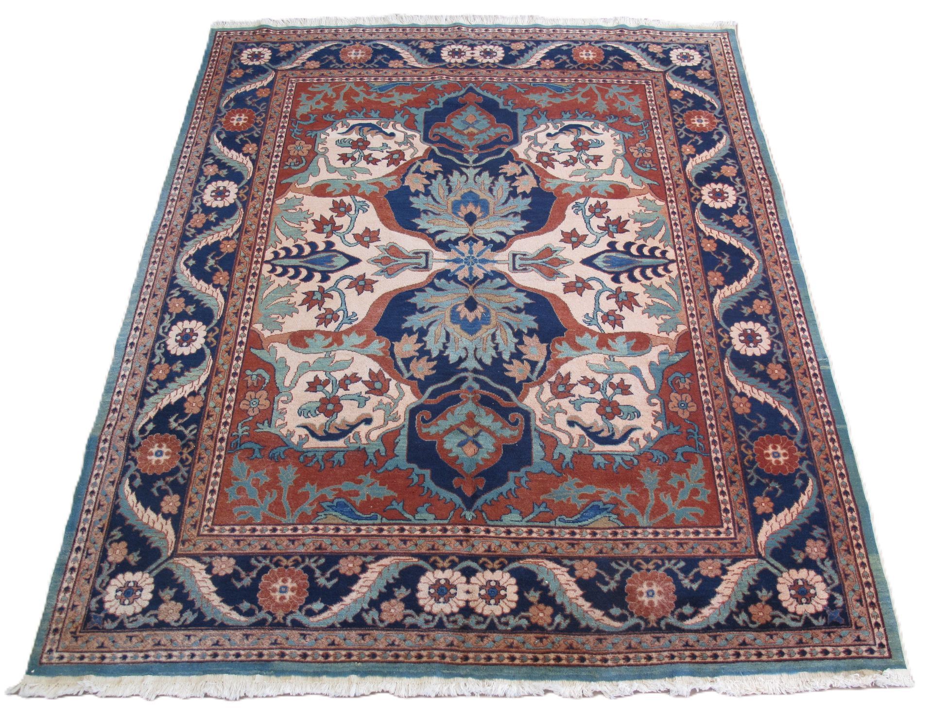 A rectangular rug with a blue and terracotta floral pattern and a fringed edge.