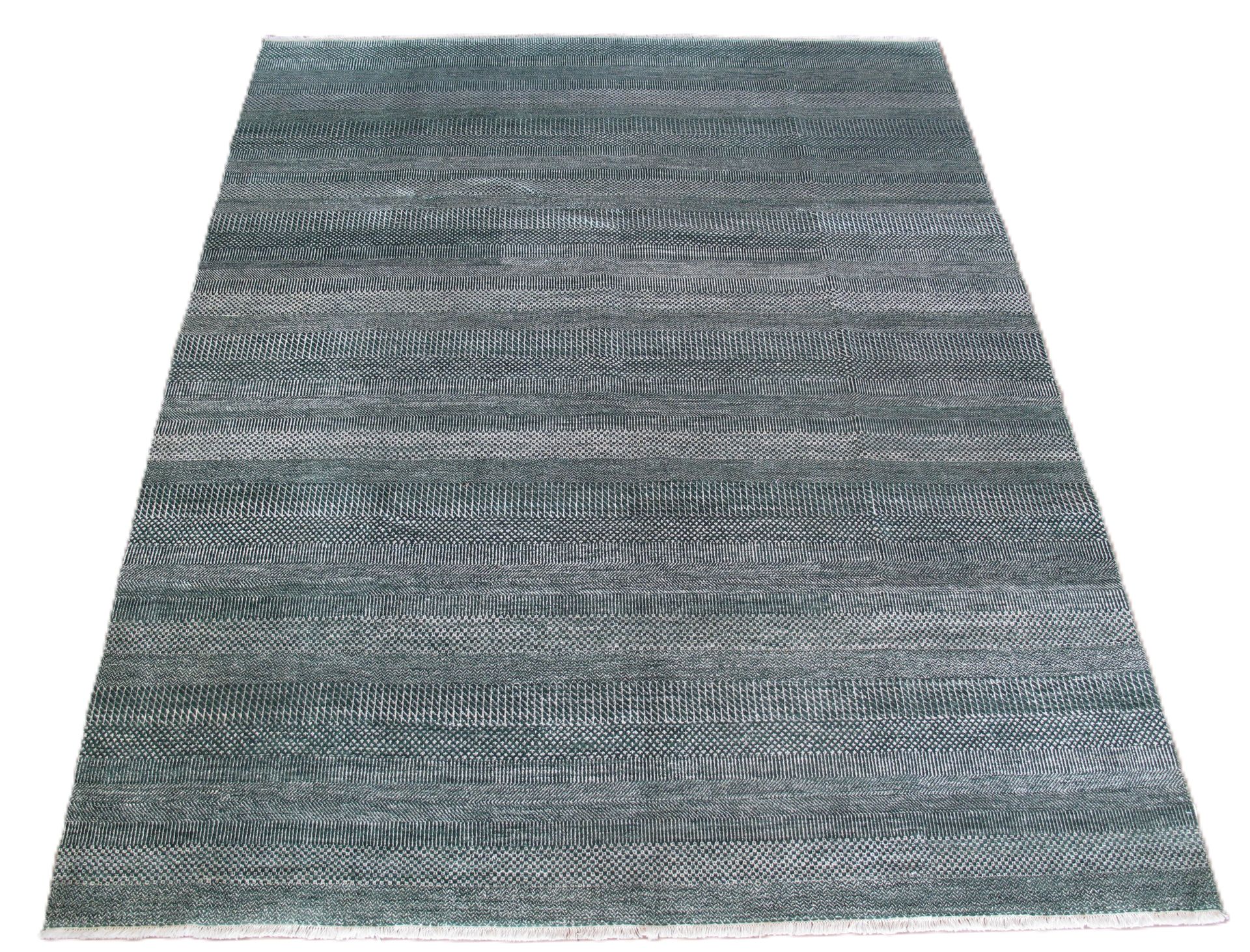 A dark gray area rug with a textured, wavy, or ribbed pattern, displayed from an angled perspective.