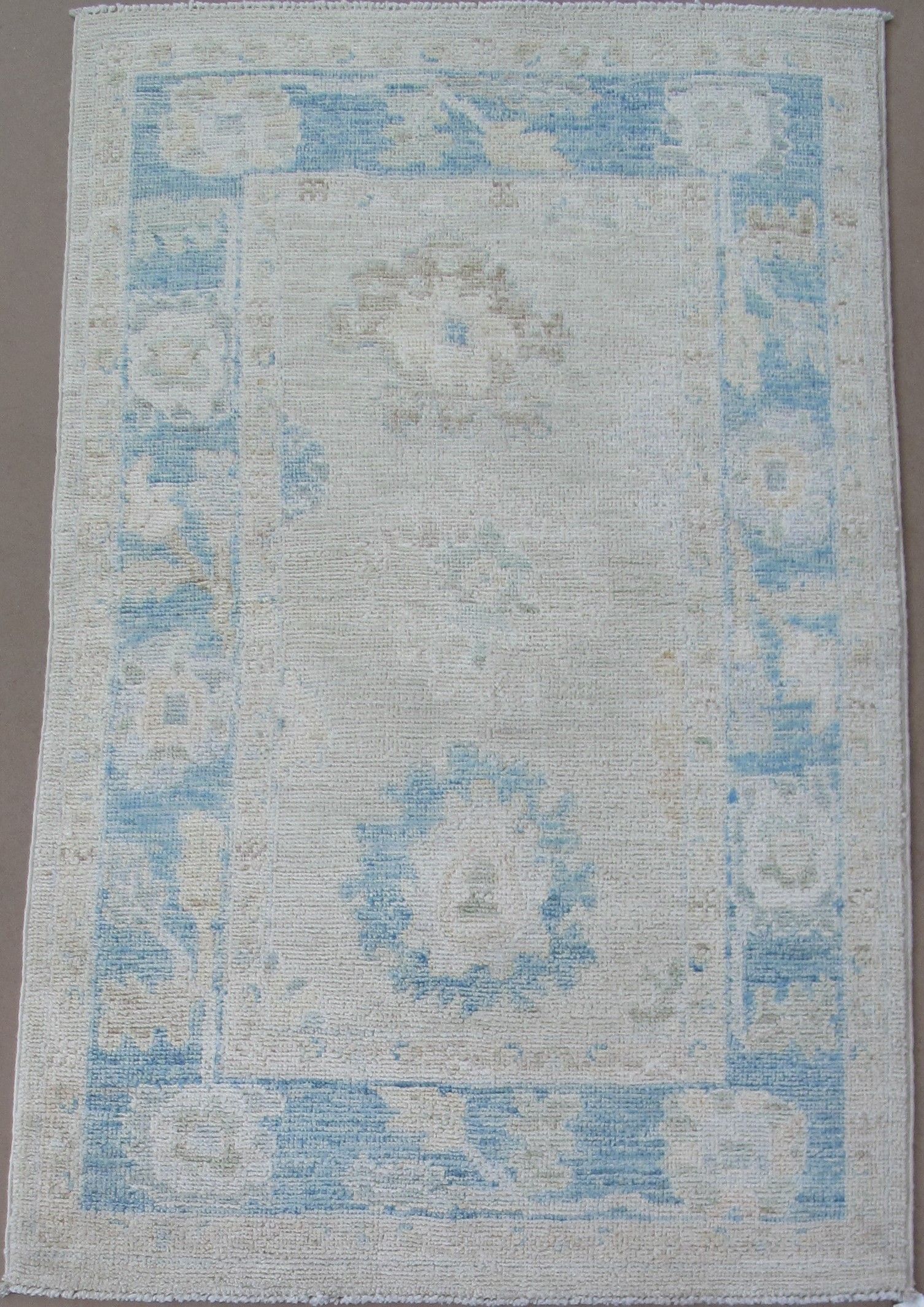 Light blue and white rectangular rug with a blue border.