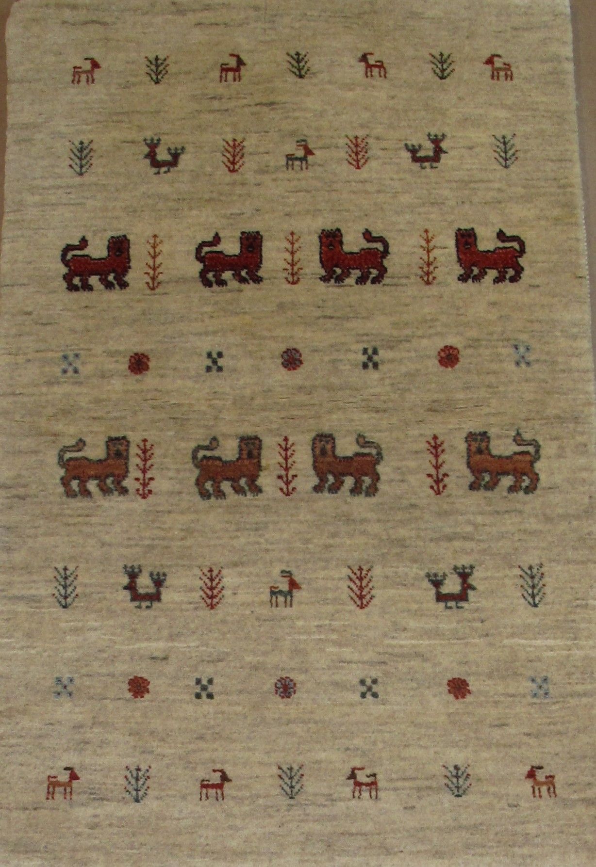 Beige rug with rows of repeating dark red lions, plants, and geometric figures.