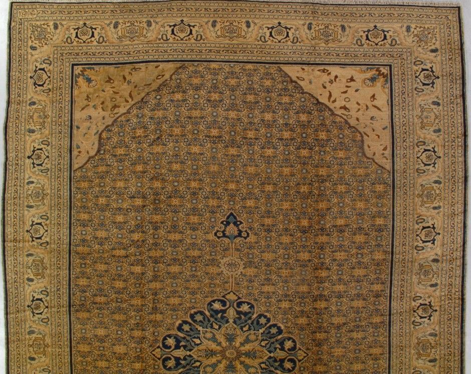 Tan and navy prayer rug with ornate border and central floral design.