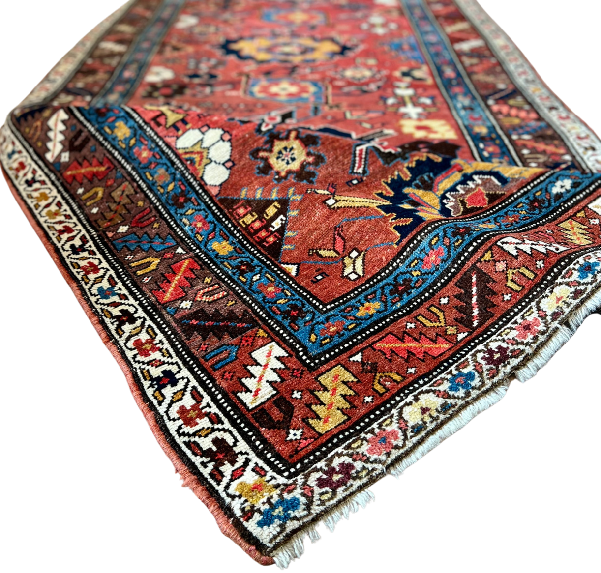 A long red and blue rug with a floral pattern on a white background.