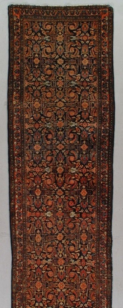 Ornate reddish-brown patterned rug with a central floral medallion and dark border
