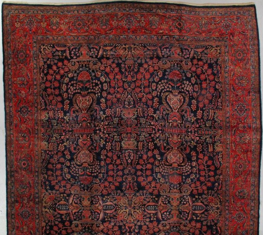 A detailed, dark blue, and red Persian-style rug with intricate floral patterns and an ornate border.