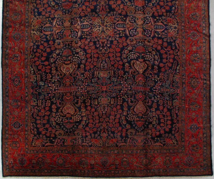 A detailed, dark blue, and red Persian-style rug with intricate floral patterns and an ornate border.