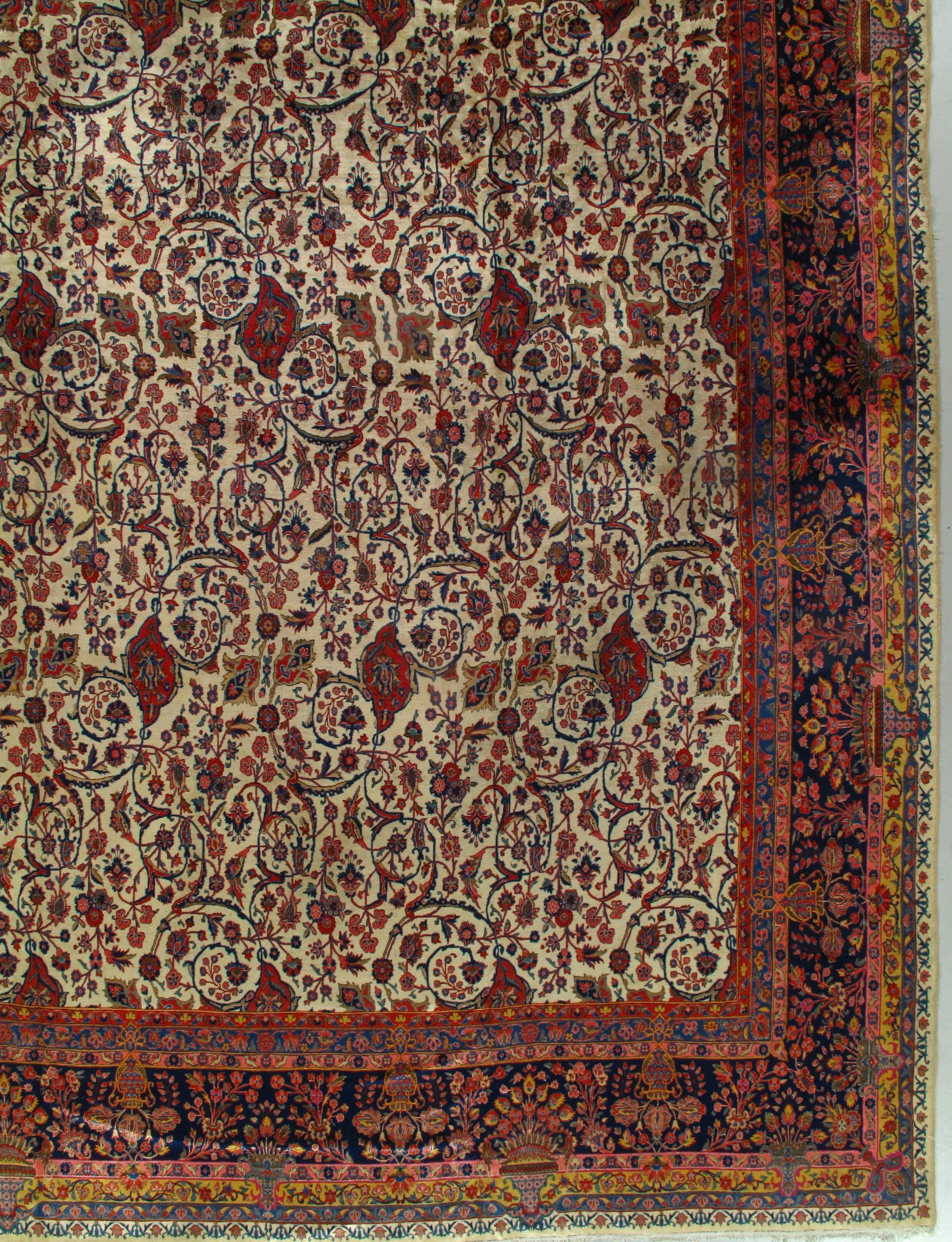 Corner of an ornate Persian rug, with floral patterns in red, cream, and navy blue.