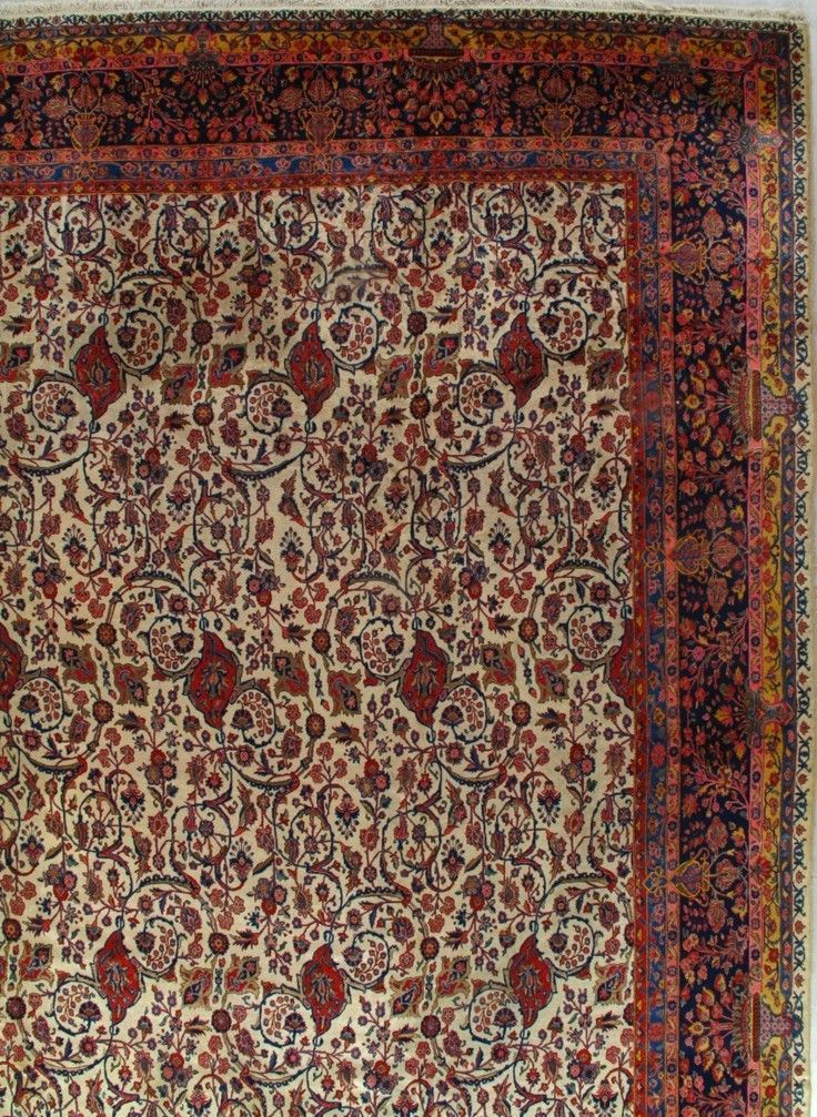 Corner of an ornate Persian rug, with floral patterns in red, cream, and navy blue.