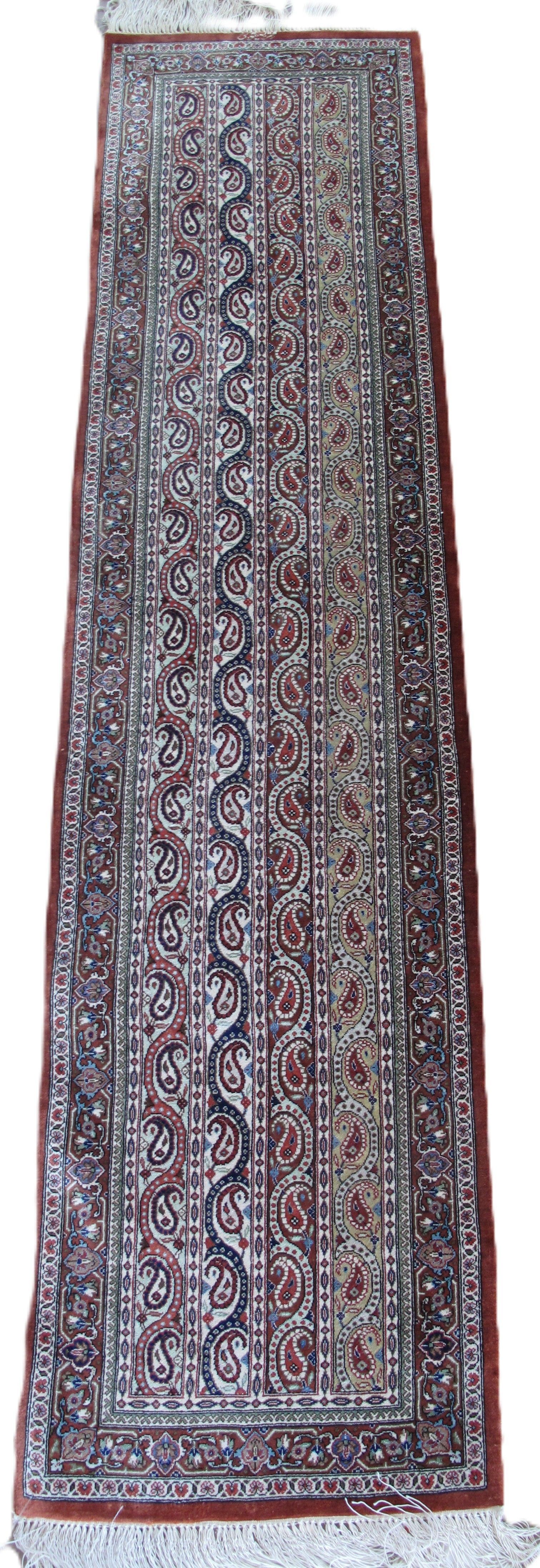 Long rectangular patterned rug in red, blue, and white with decorative border