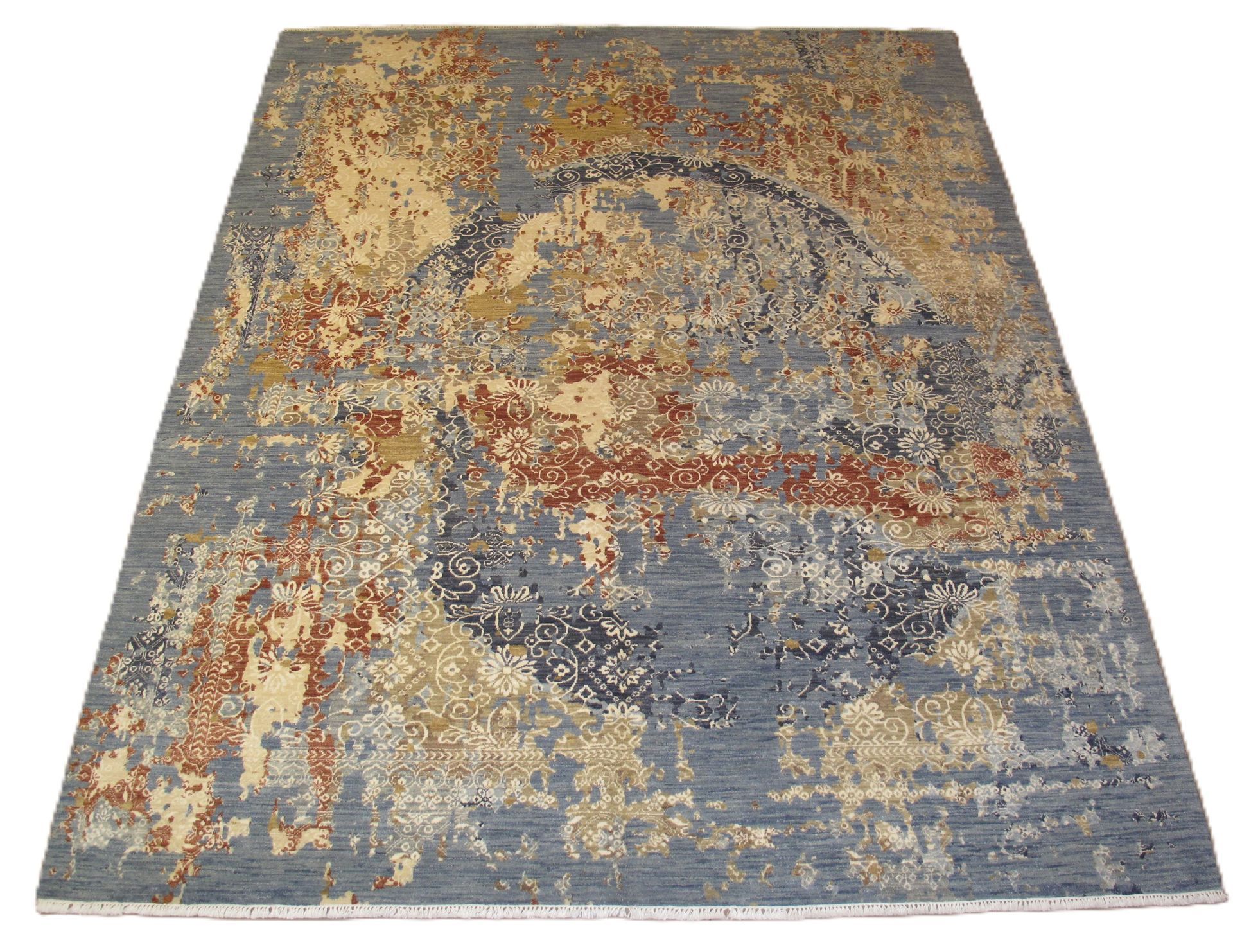 Blue, beige, and rust-colored rectangular rug with a circular design and distressed appearance.